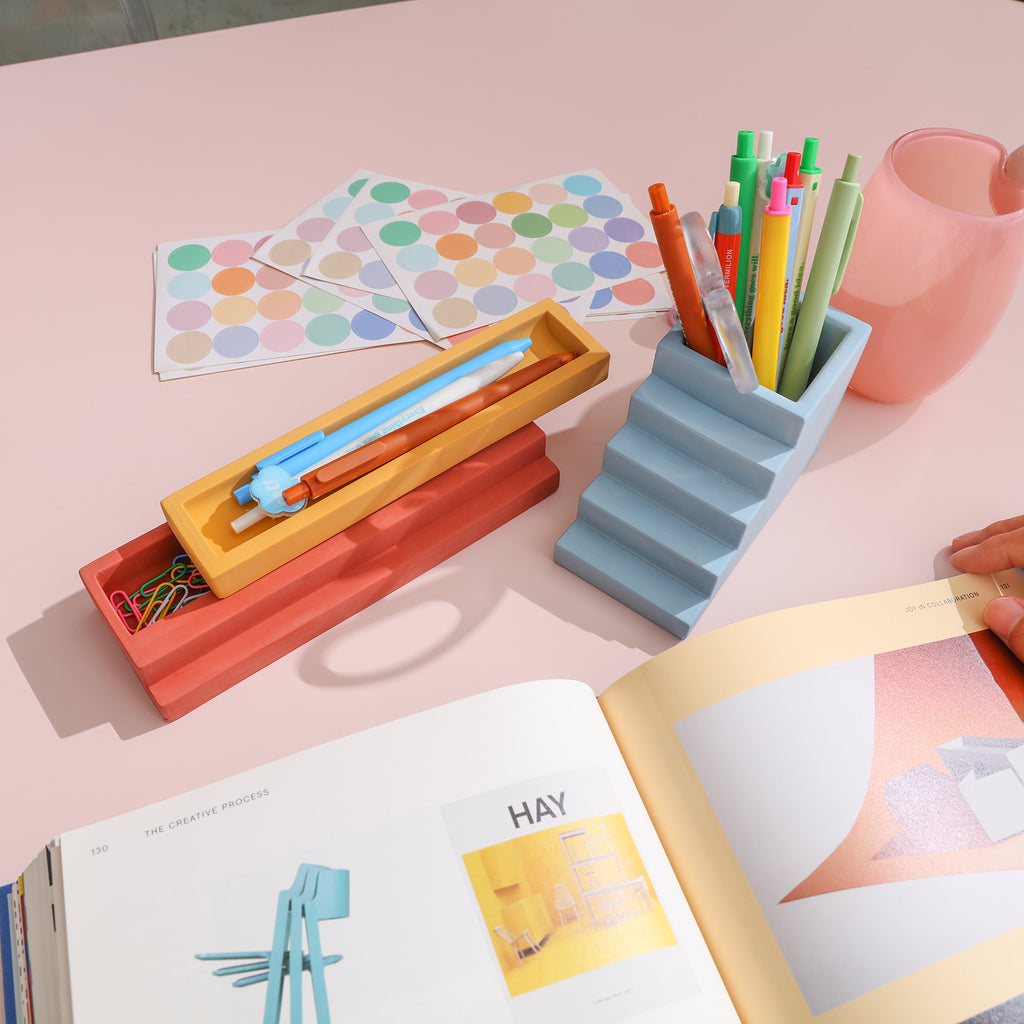 Pen Holders of different shapes and colors on the desk help office life-Boowan Nicole