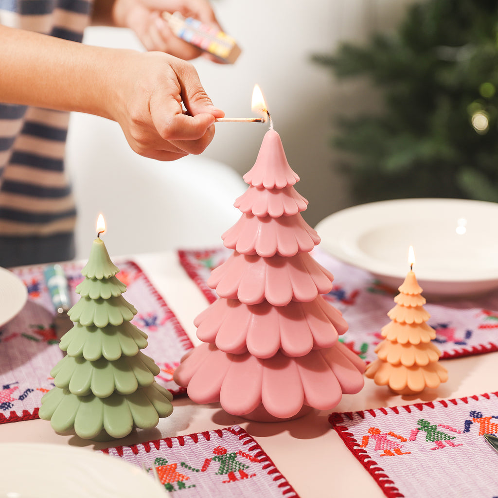 Light the 8-inch Christmas tree candle on the dining table, designed by Boowan Nicole.