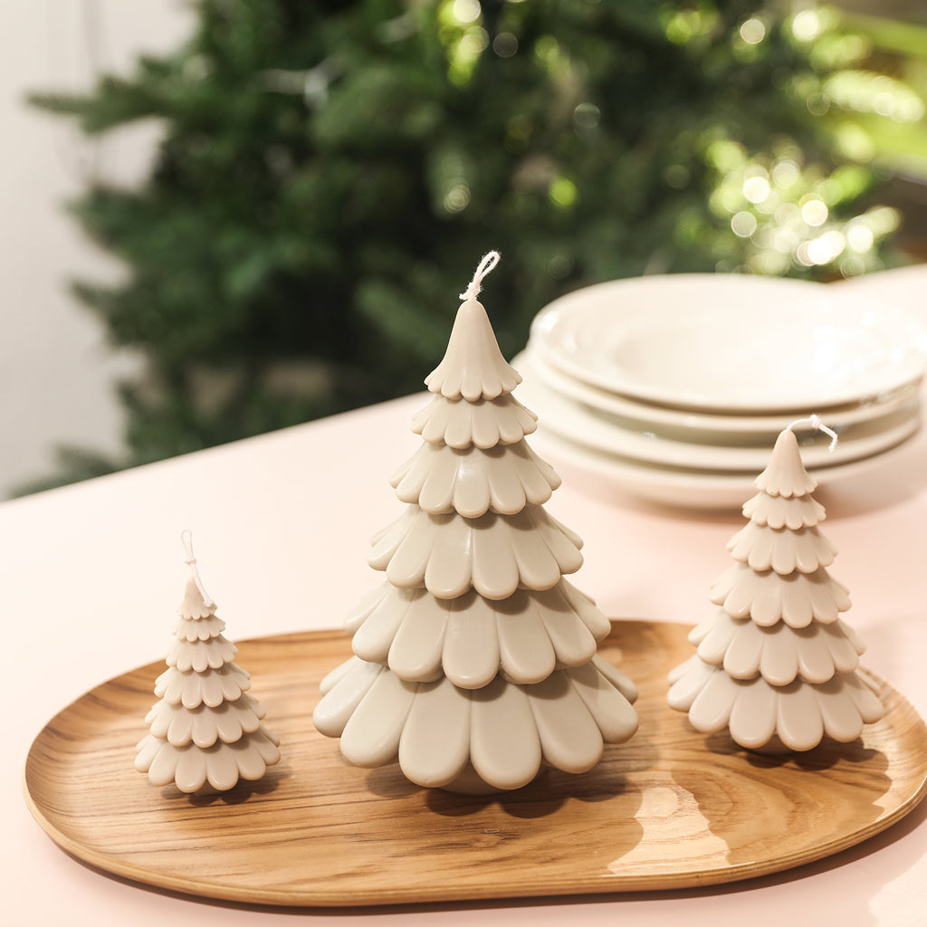 Christmas tree candles of different sizes placed on a tray, designed by Boowan Nicole.
