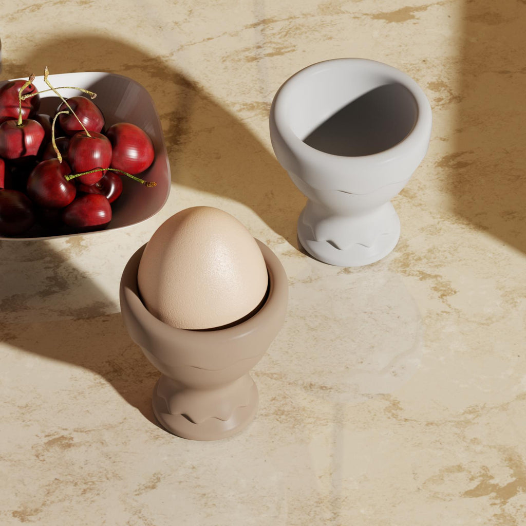 One egg cup with an egg, the other empty.