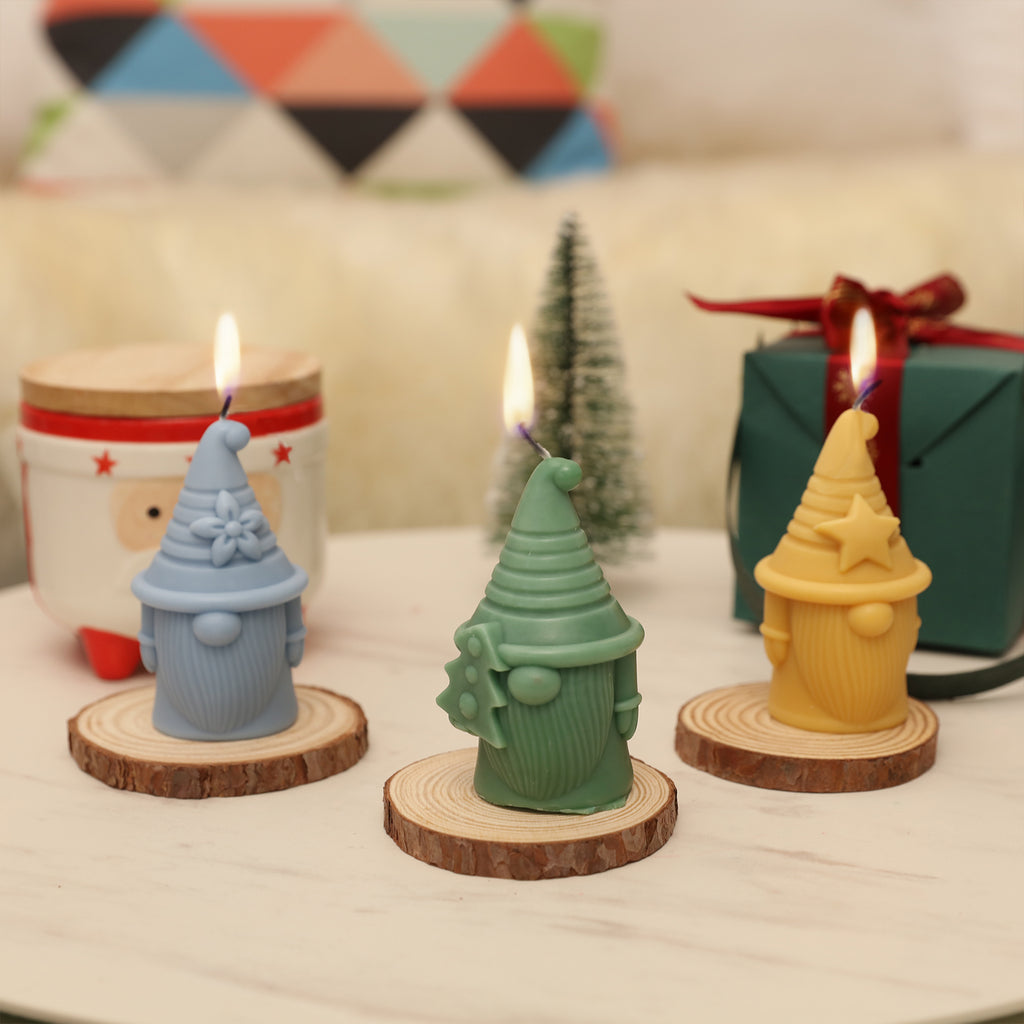 Florian of Hat-tastic Gnome Squad Candle in three different shapes of blue, green and yellow is burning slowly -Boowan Nicole