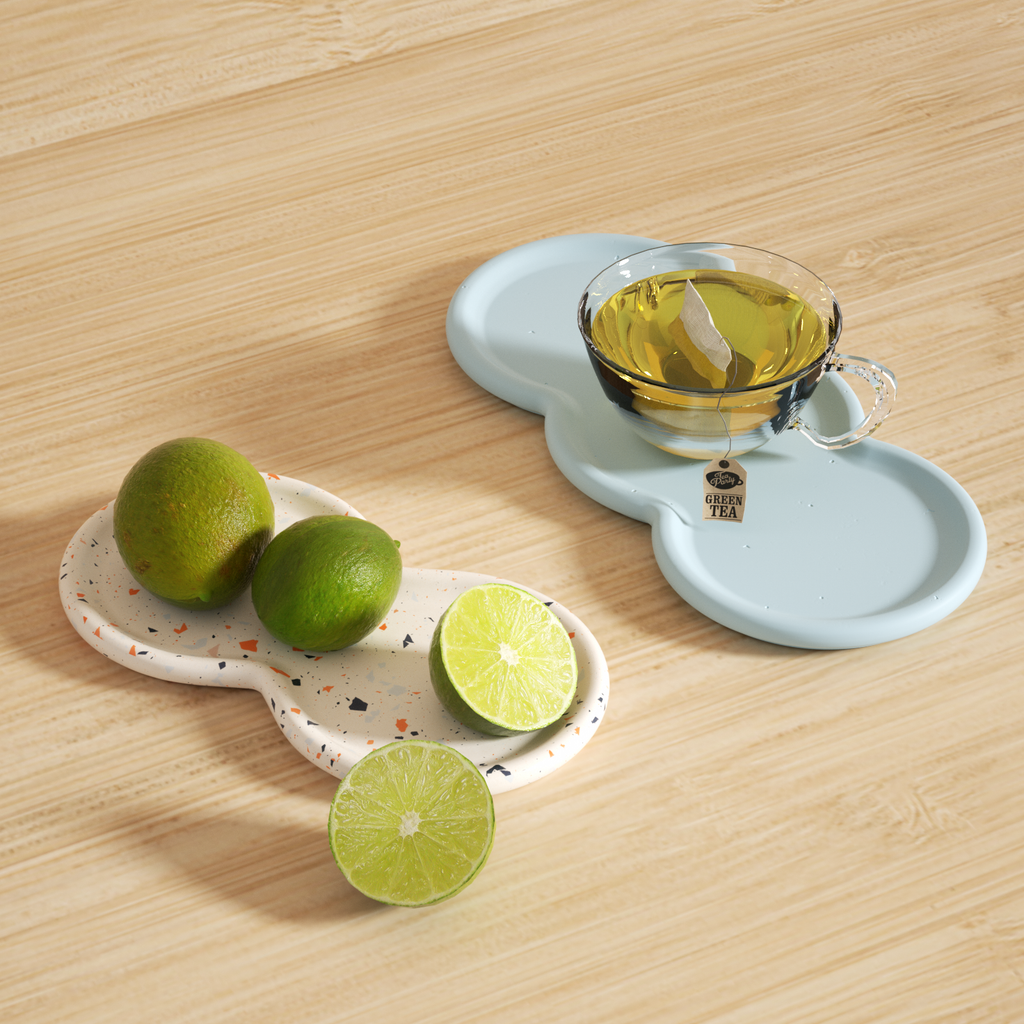 A cup of tea on a blue Double-Nut Peanut-Shaped Tray and a cut lemon on another white terrazzo tray - Boowan Nicole