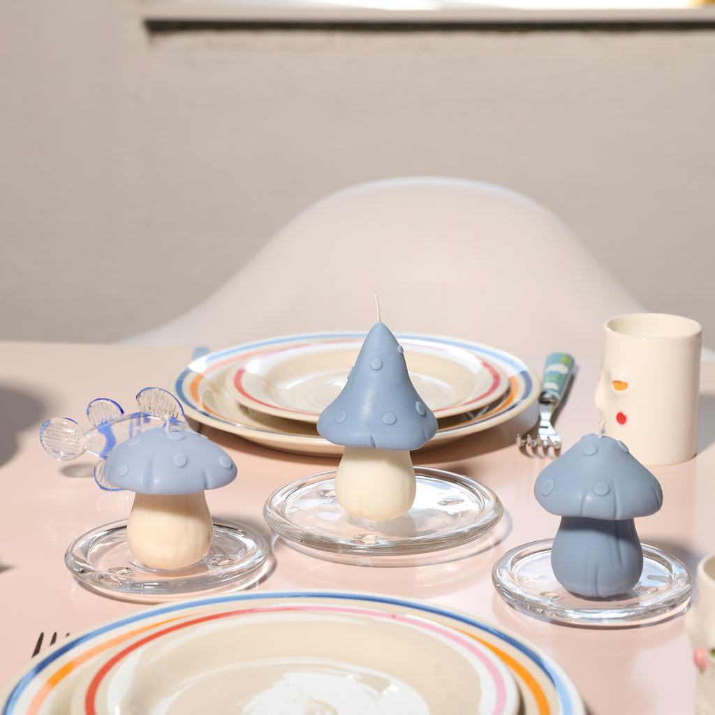 Three blue mushroom-shaped candles are placed on the crystal tray on the dining table, designed by Boowan Nicole.