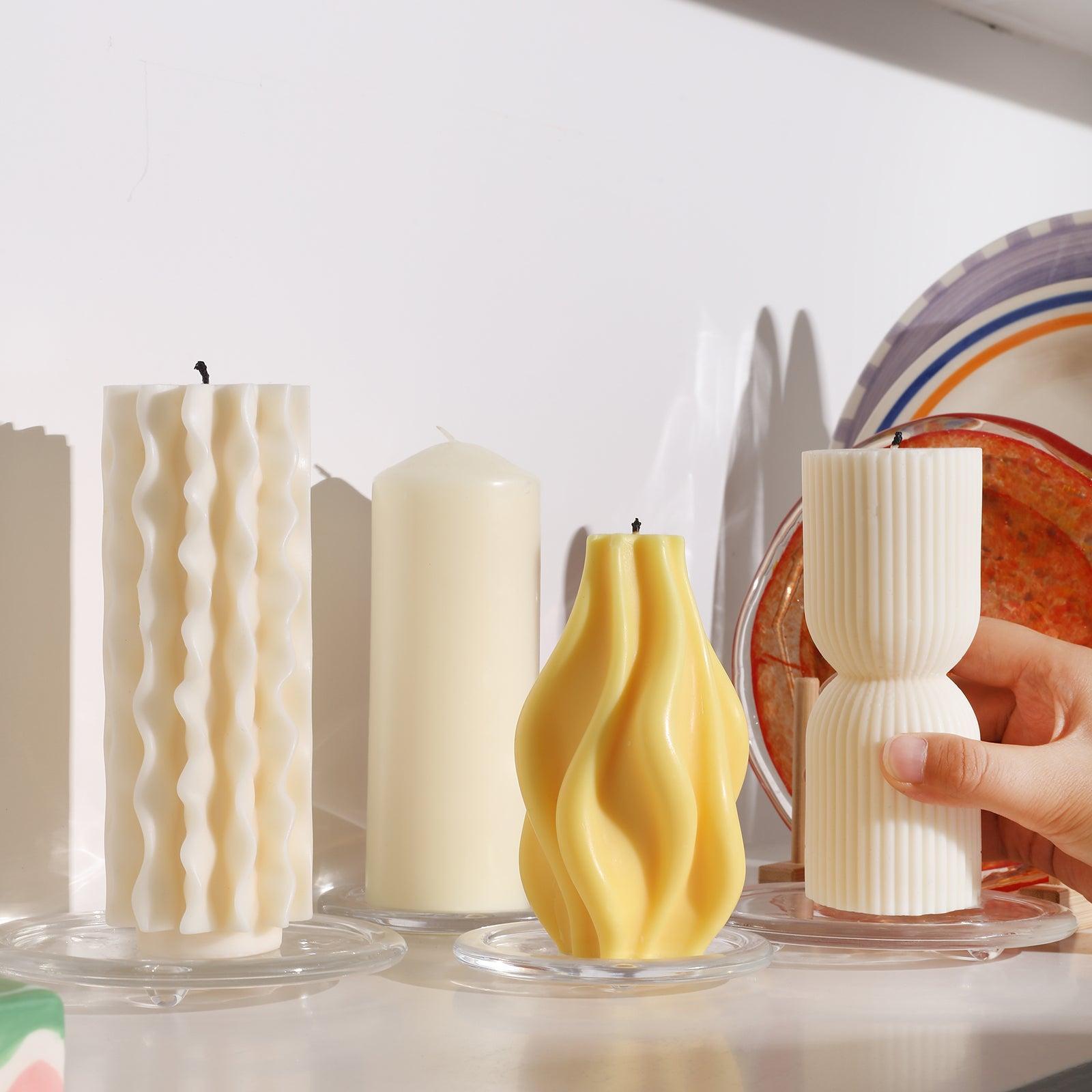 Four candles of different shapes placed on glass trays-Boowan Nicole