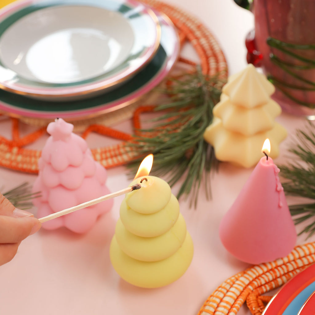 Use a match to light the yellow Glowing Christmas Tree Candle on the table - Boowan Nicole