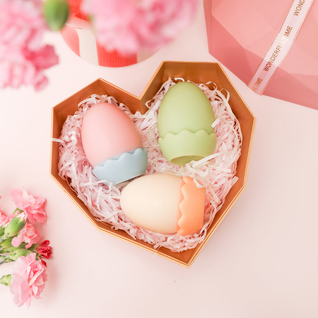 Three colorful egg candles presented in a gift box.
