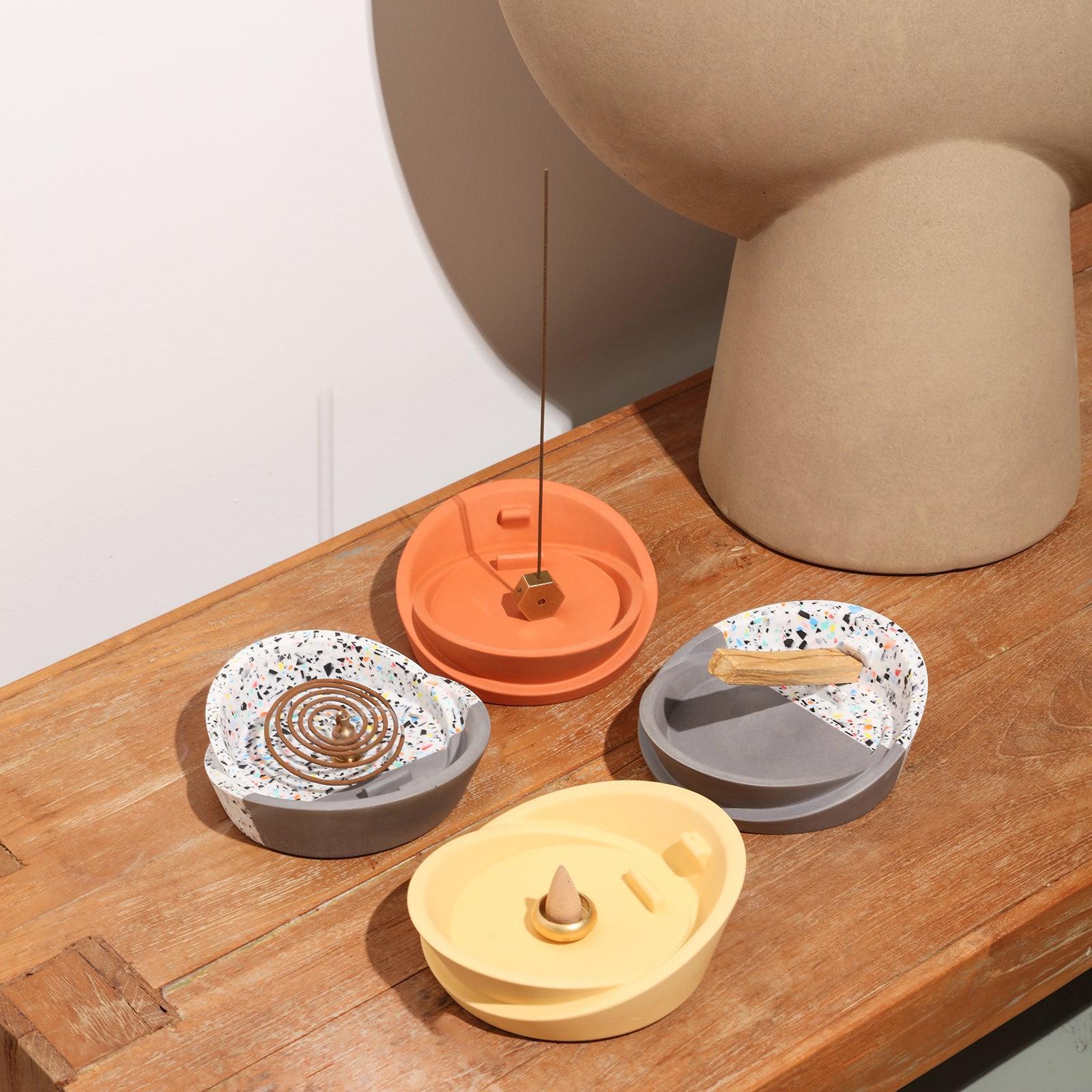 The Sail-Shape Incense Holder in red and yellow with terrazzo is placed on the table - Boowan Nicole