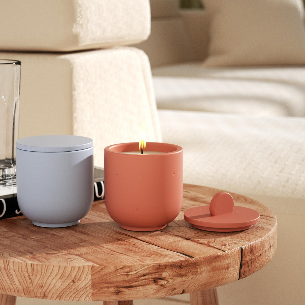 Blue candle jar with flat lid and lit orange candle jar