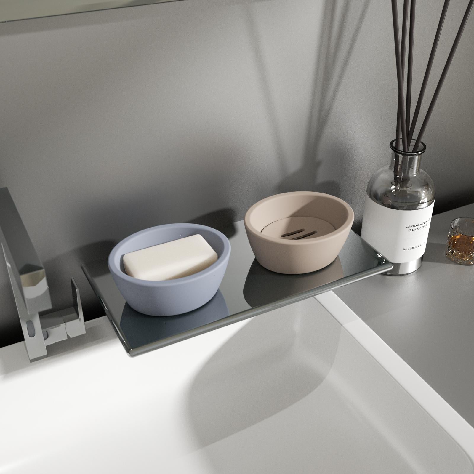 Blue and gray soap dishes sit on the sink shelf, one of which holds soap.