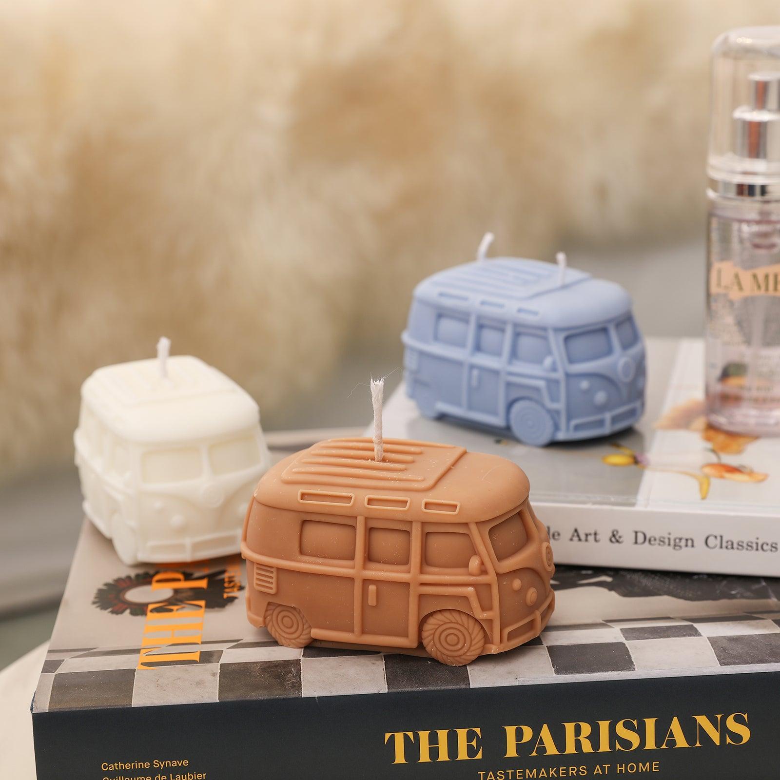 White, blue and brown Kombi Vintage Camper Van Candle-Boowan Nicole placed on the book