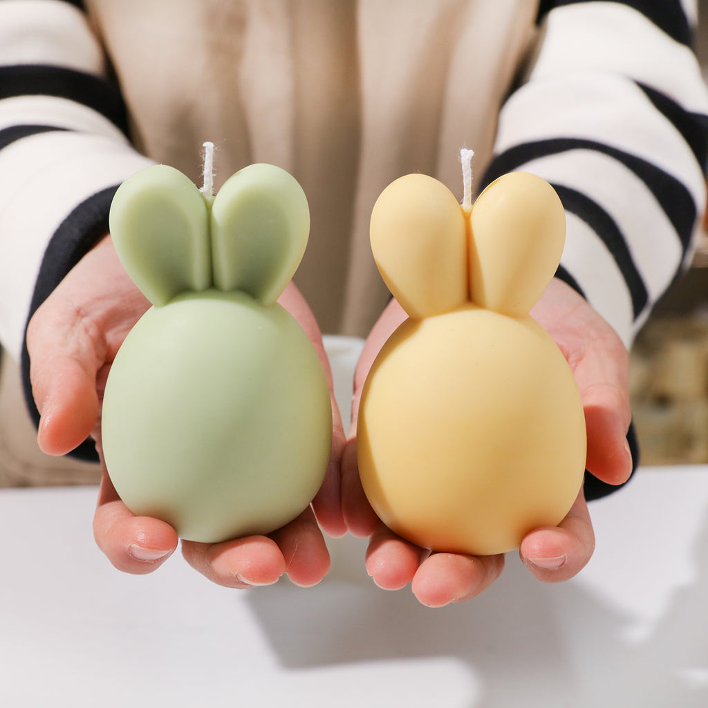 Display of two Bunny Candles with colorful designs.