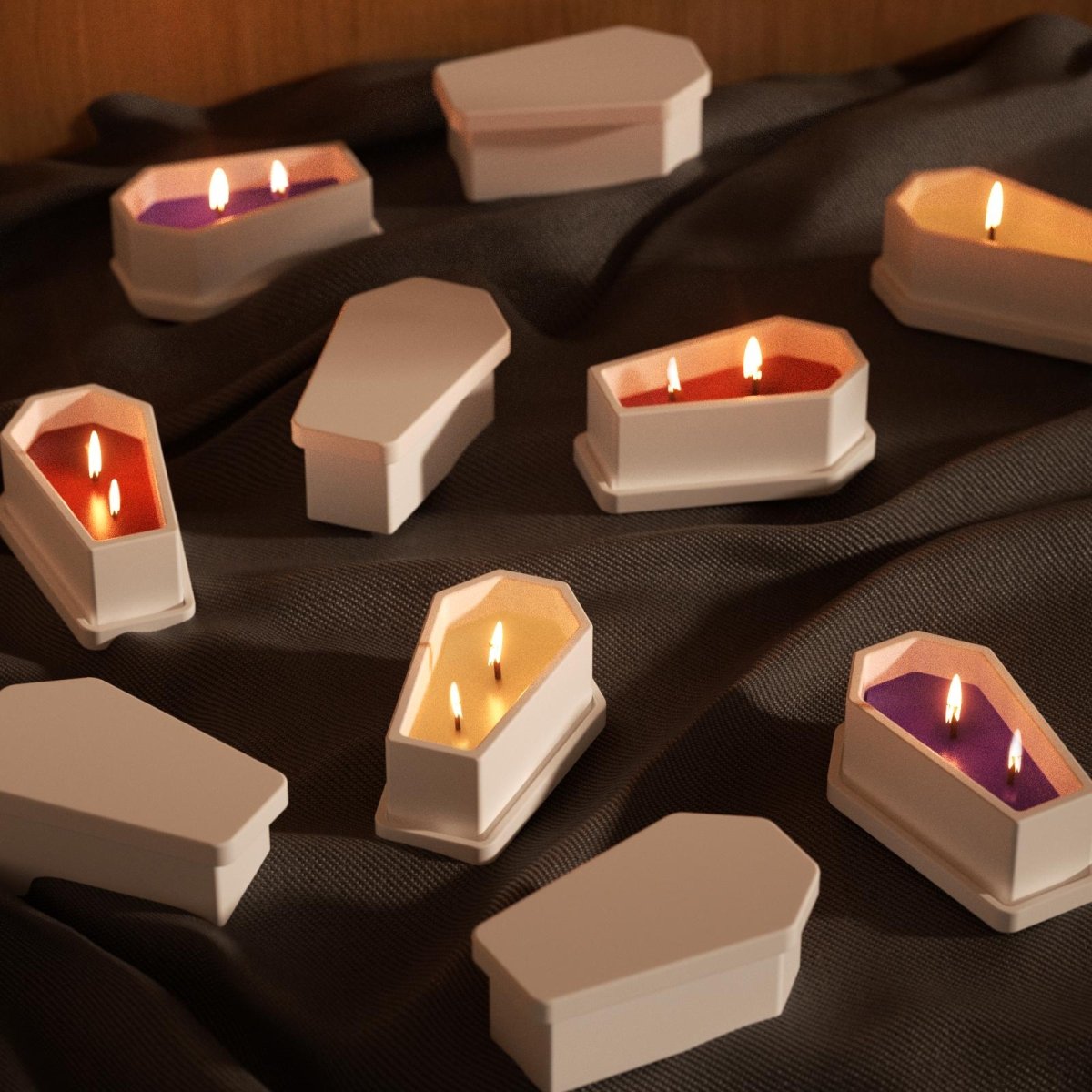 White coffin-shaped Halloween candles with colorful wax and triple wicks, displayed on dark fabric for a spooky seasonal vibe - Boowan Nicole