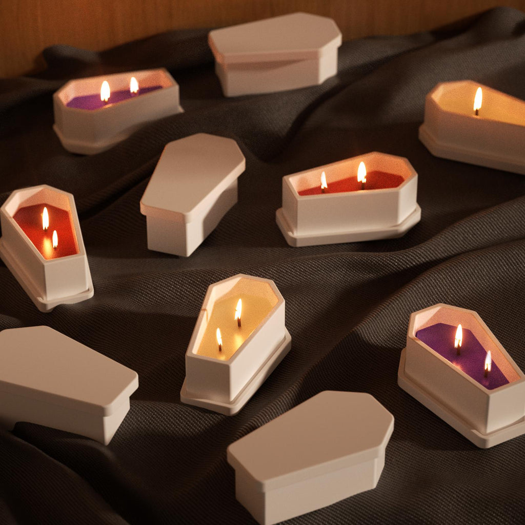 White coffin-shaped Halloween candles with colorful wax and triple wicks, displayed on dark fabric for a spooky seasonal vibe - Boowan Nicole