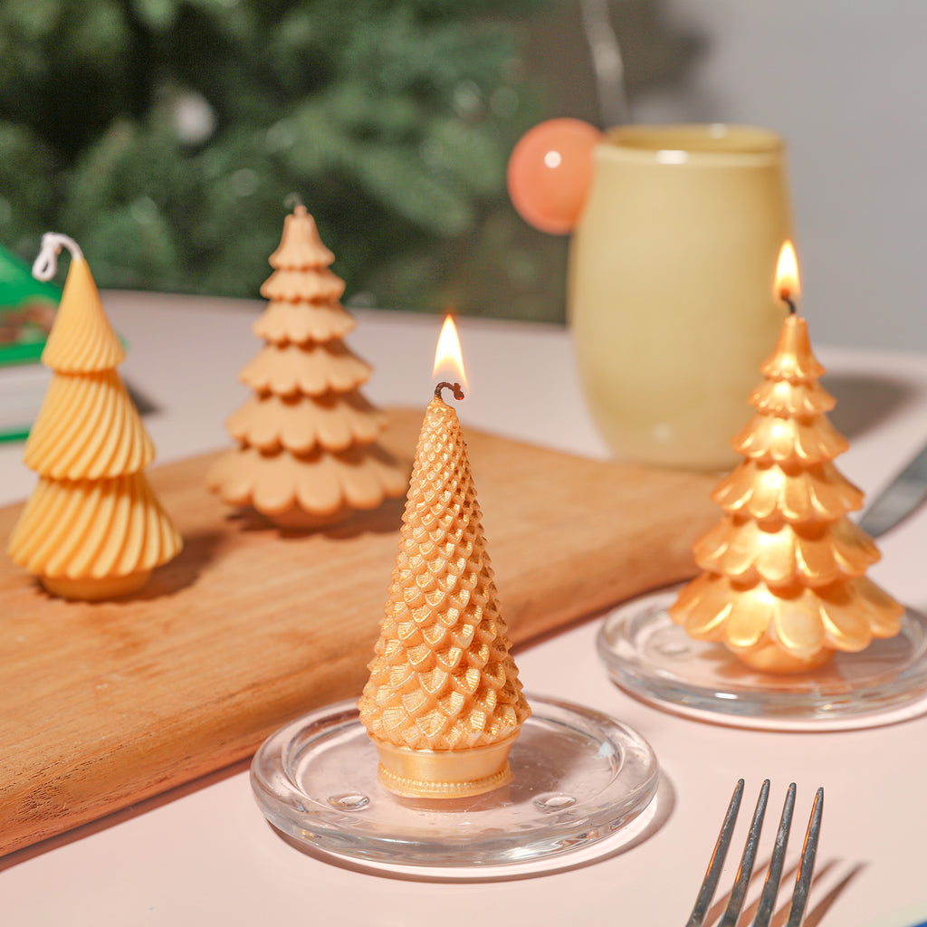 The Christmas tree candles painted with golden mica powder are lit on a crystal tray, showing the craftsmanship.