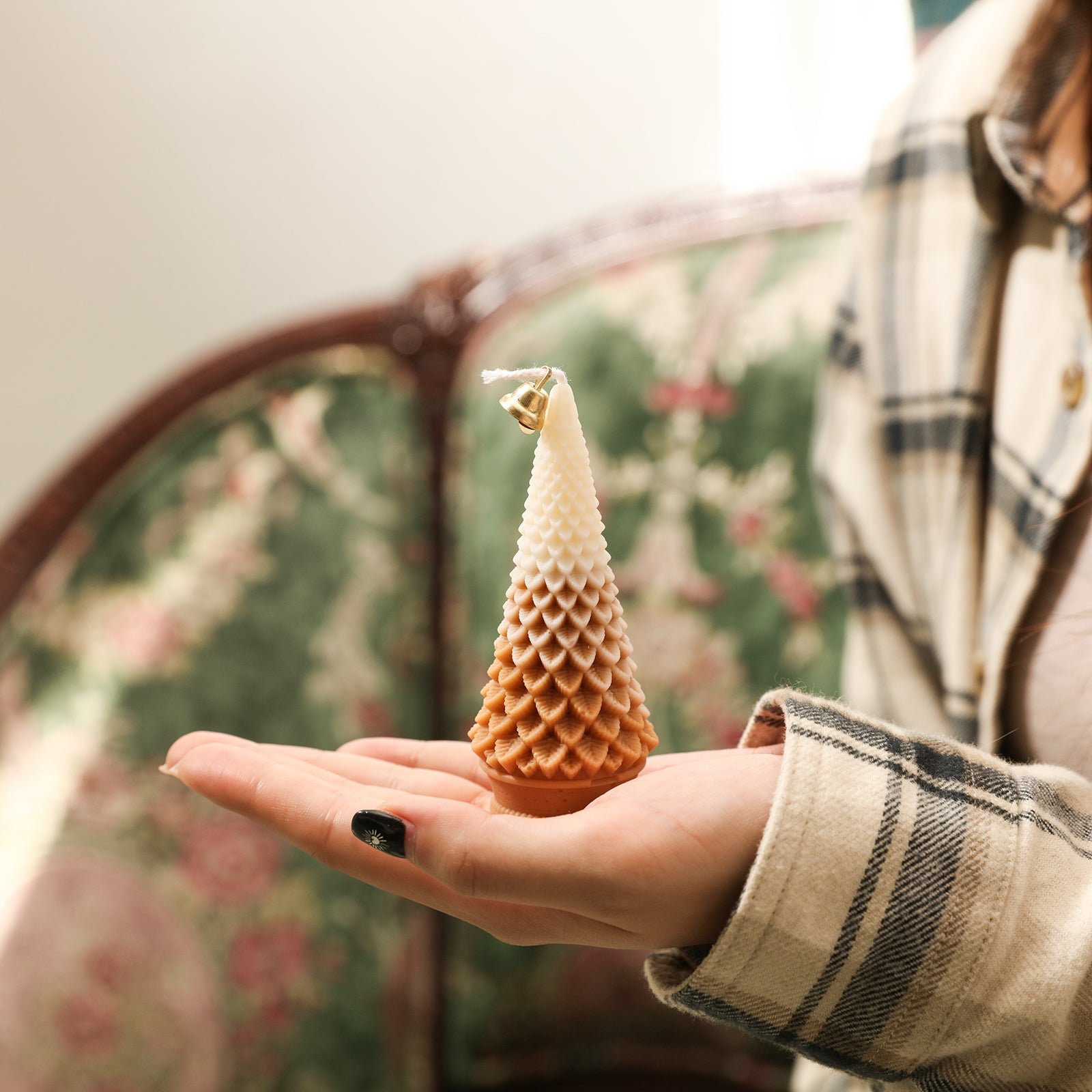 Half brown and half white tapered Christmas tree candle in the palm of the hand - Boowan Nicole