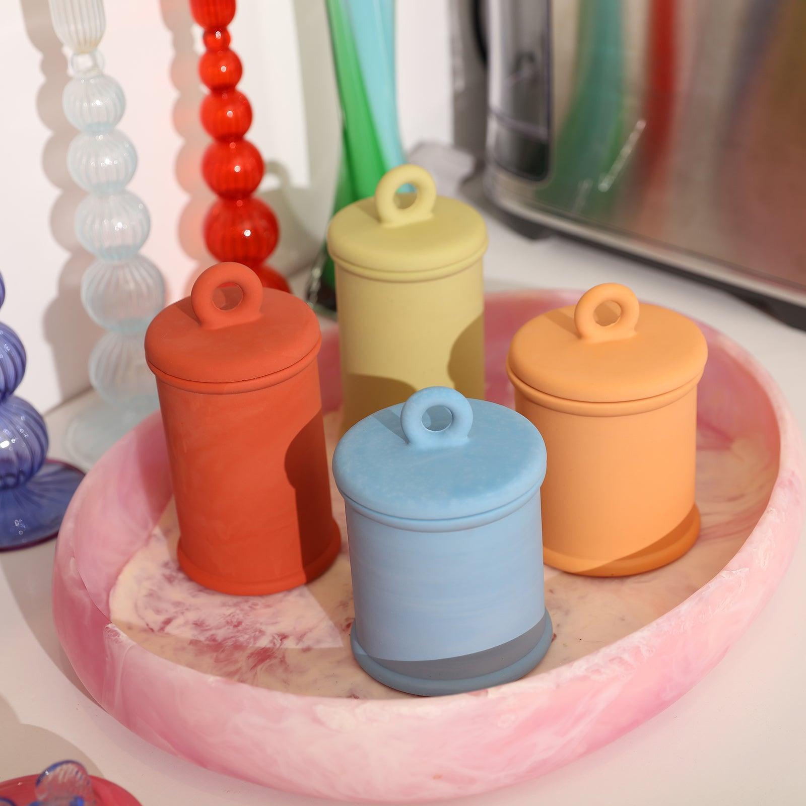 Yellow and red Cylinder tall Candle Jar and blue and yellow-pink Cylinder short Candle Jar are placed on the tray-Boowan Nicole