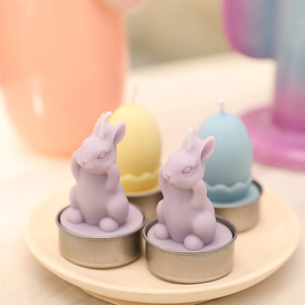 Four Easter tealight candles arranged on a small tray.