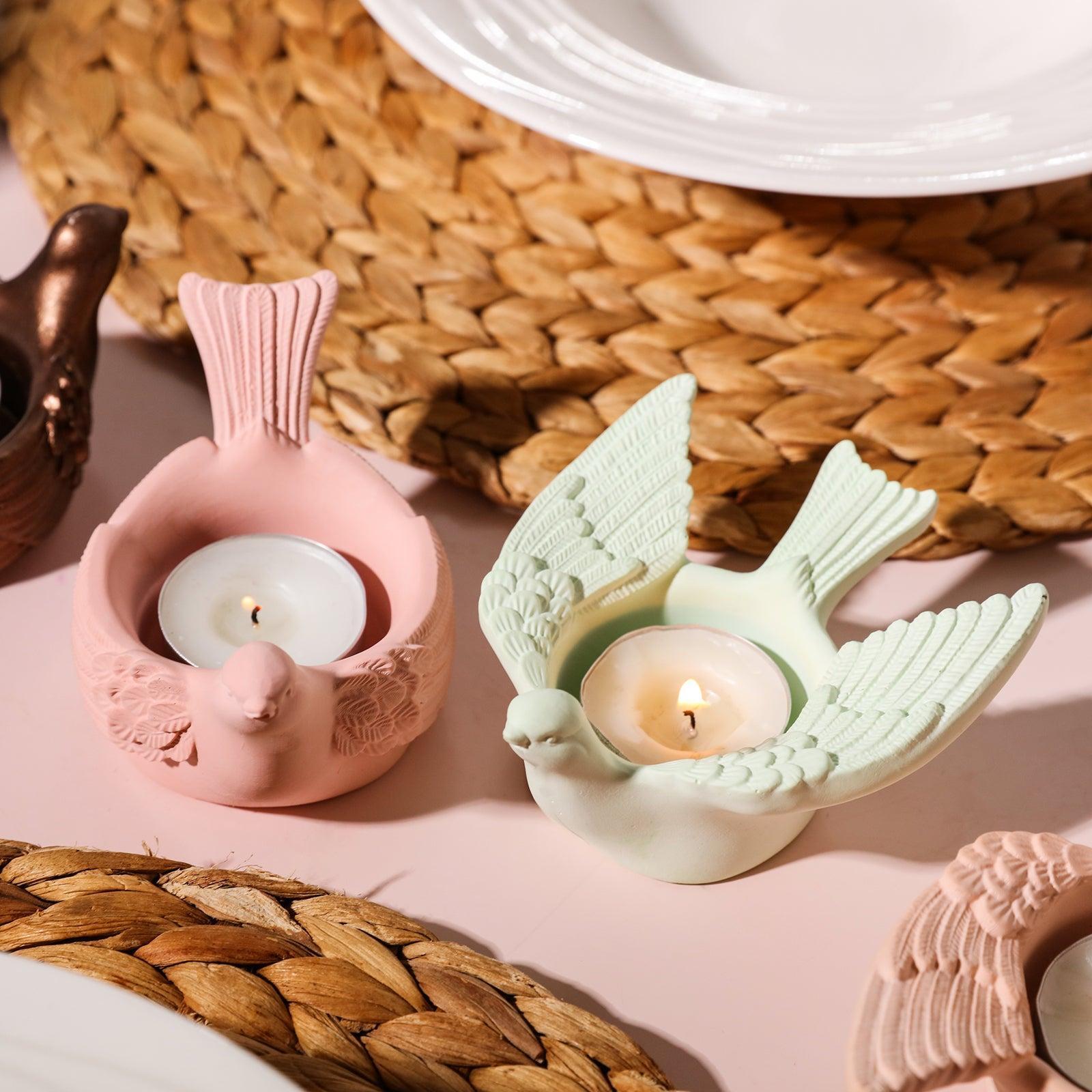 Two tealight candle holders with burning tealight candles.