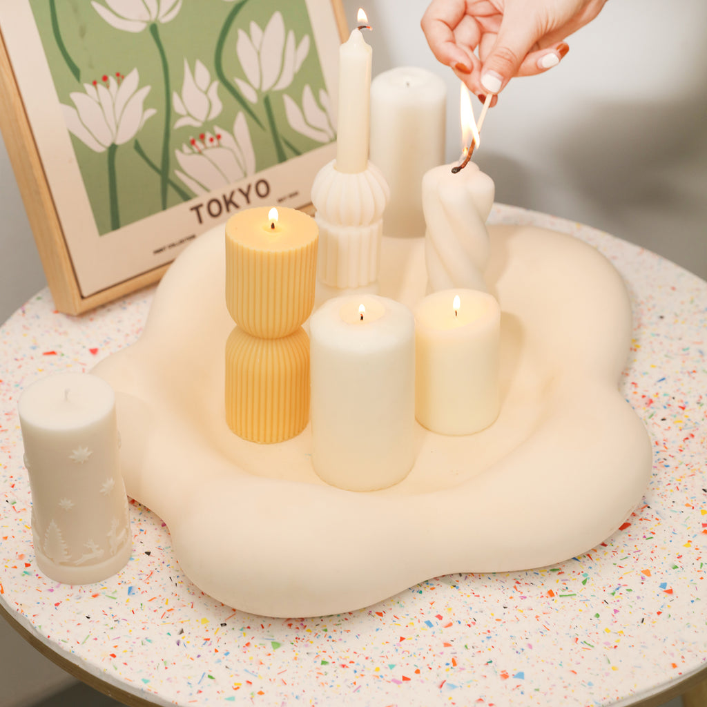 The large flower-shaped tray on the table holds lit candles for diverse usage scenarios.