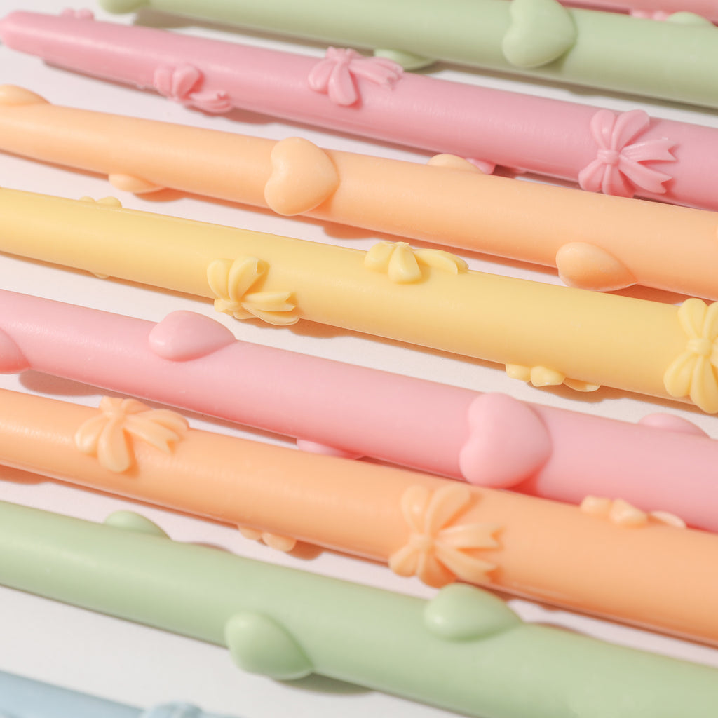 A delightful assortment of Ribbon Bow Taper Candles in various hues, showcasing the versatility of color options available.