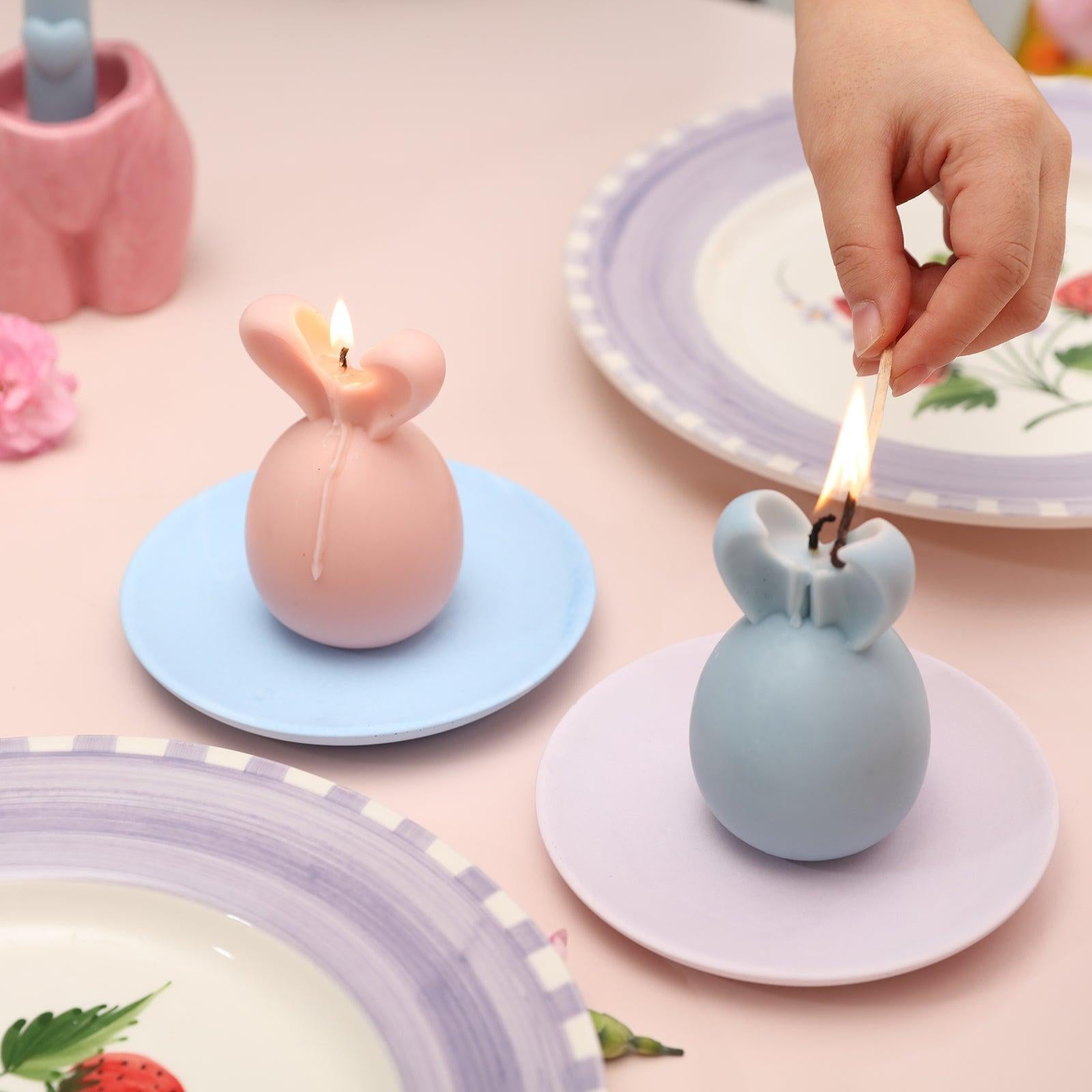 Easter bunny candles in two trays being lit in sequence.