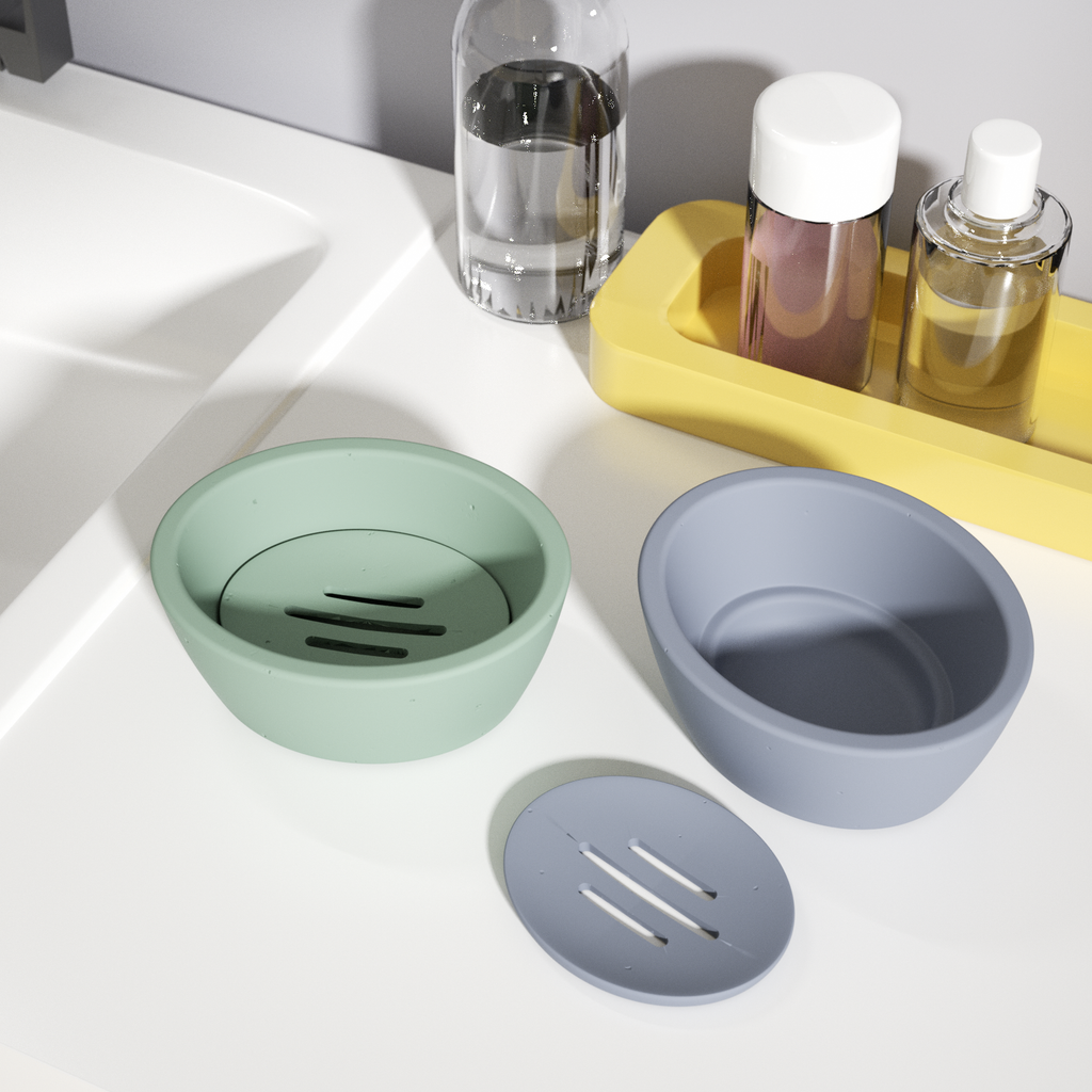 Green and blue-gray soap dishes are placed on the sink shelf, and the drain tray of the blue-gray soap dish is put aside to display product details.