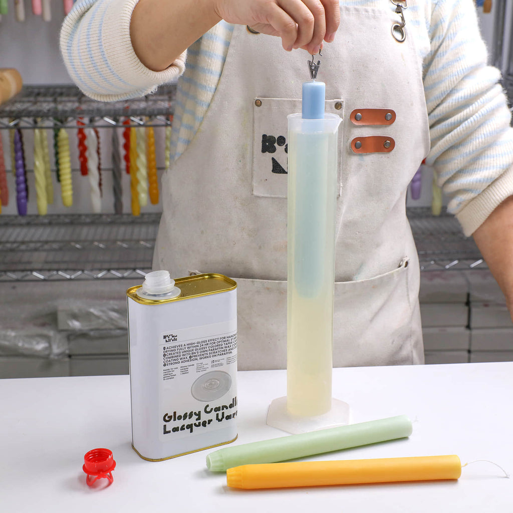 Dipping a blue 9.3" taper candle into glossy lacquer varnish for a high-shine finish - Boowan Nicole