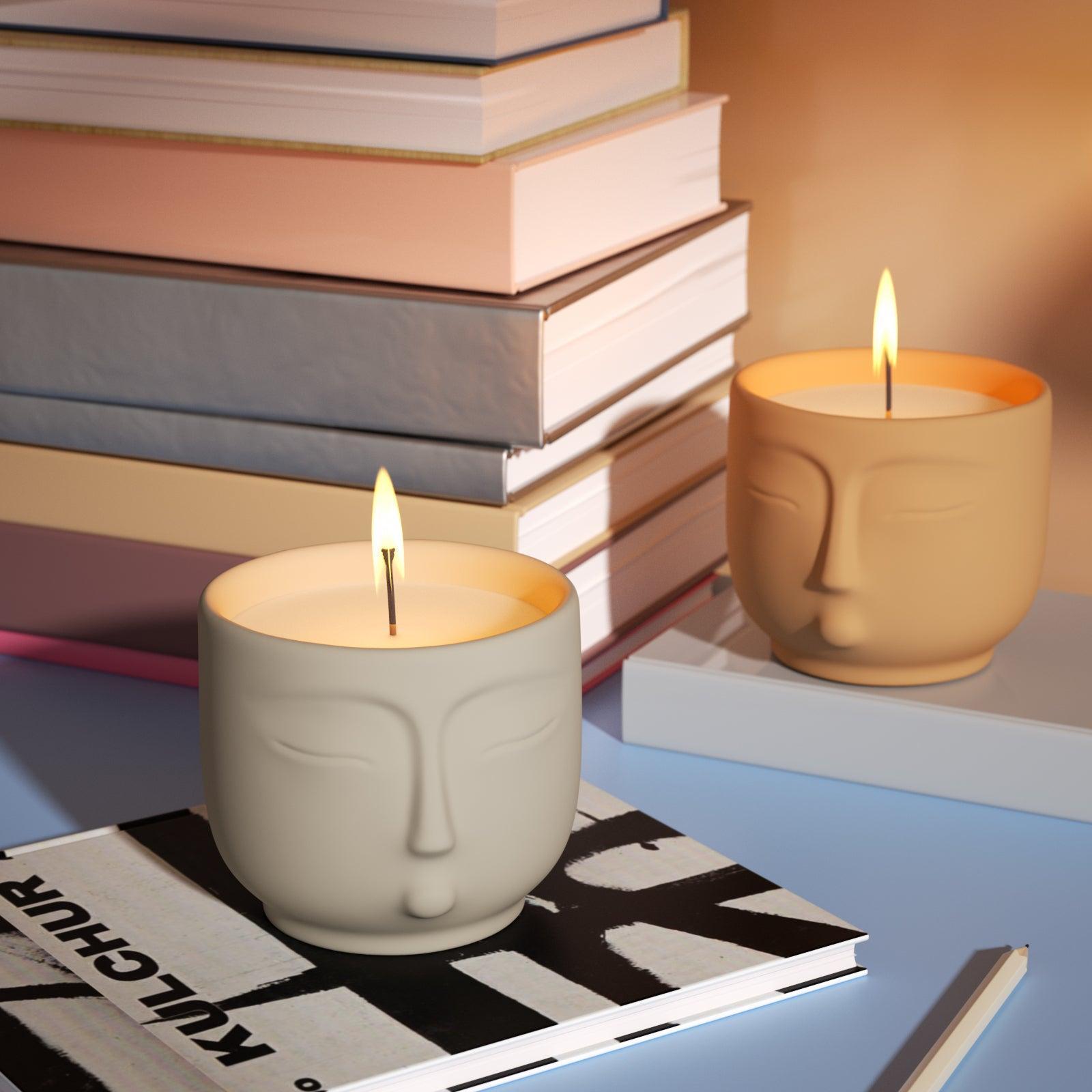 Light white and yellow face candle jar placed on book - Boowan Nicole