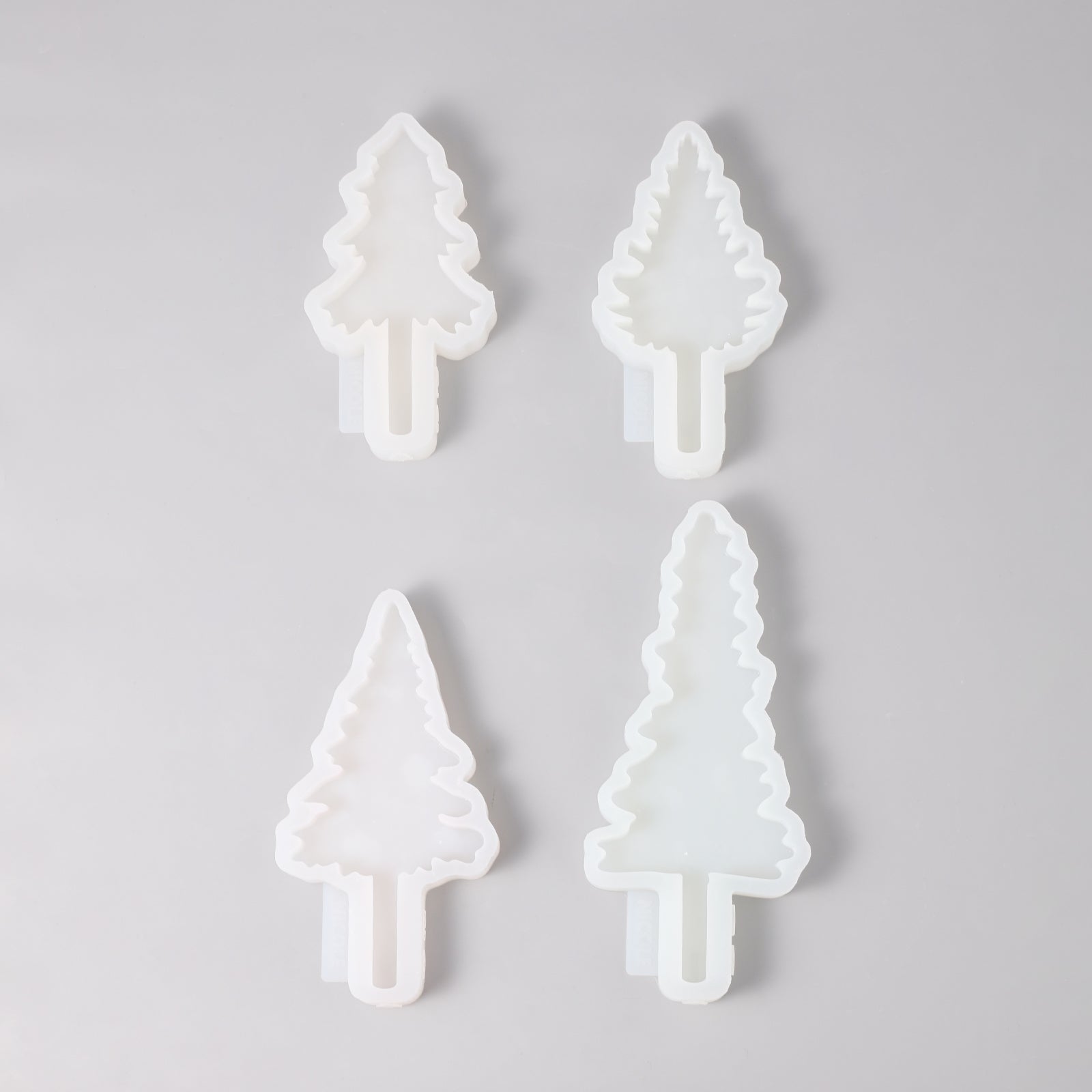 Four Christmas tree-shaped silicone molds of different sizes and shapes.