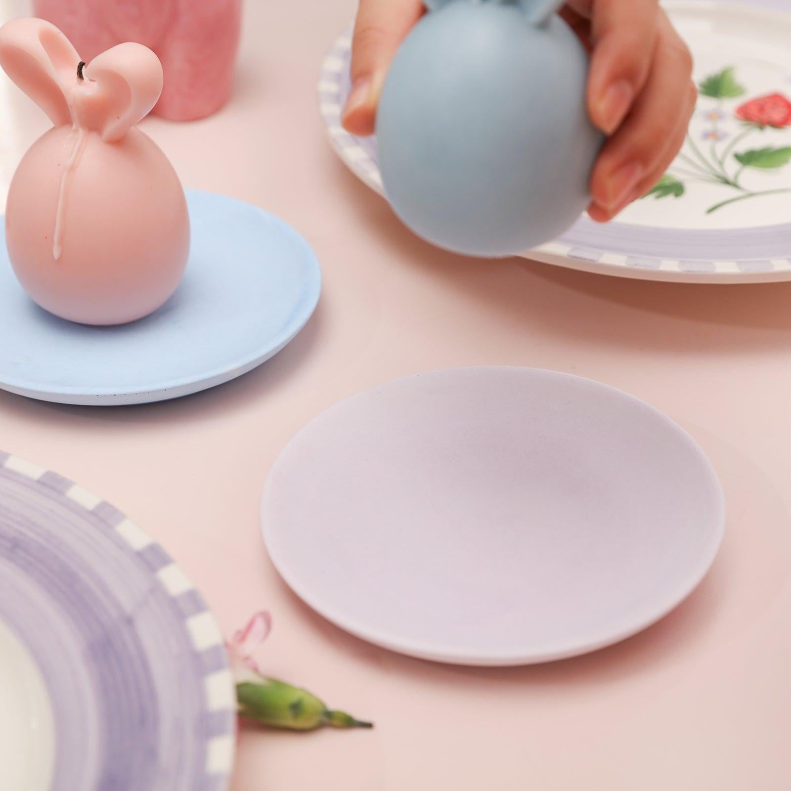 Placing lit Easter bunny candles into the trays.