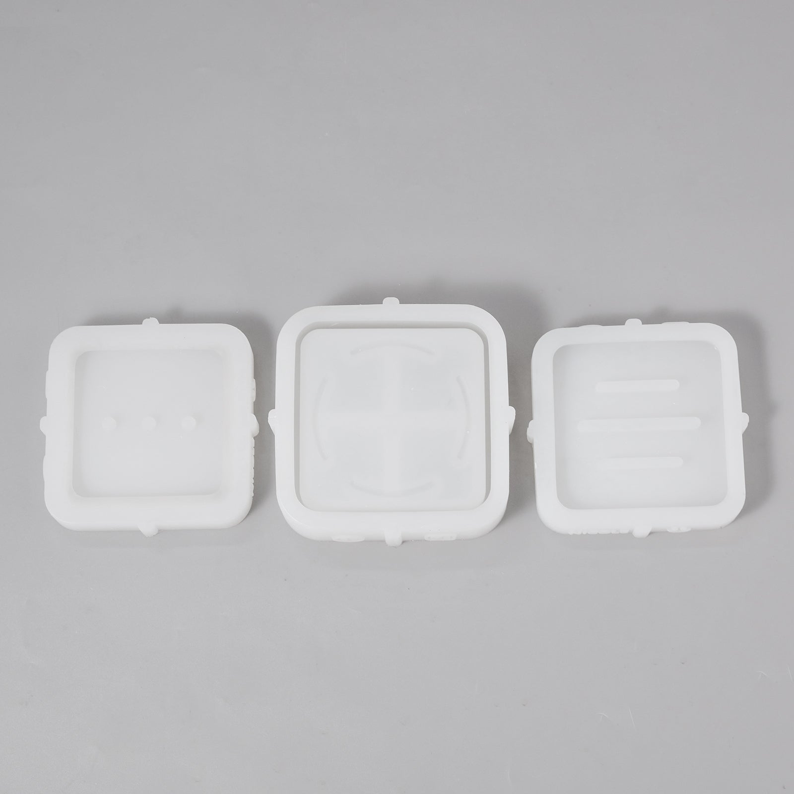 Three silicone molds, tools for crafting handmade soap.