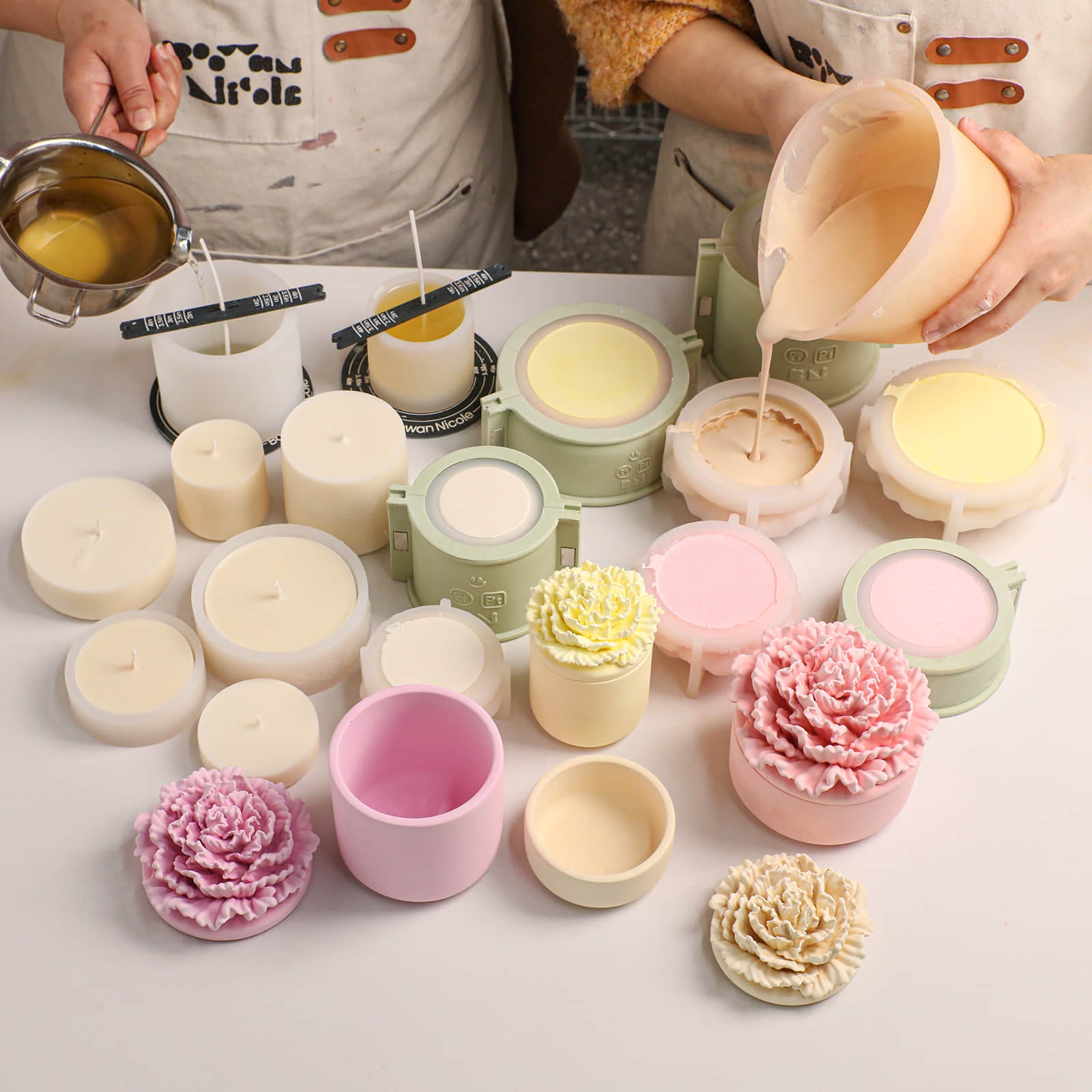 Candle making process: pouring wax into carnation jar molds with finished crafts on the table -Boowan Nicole