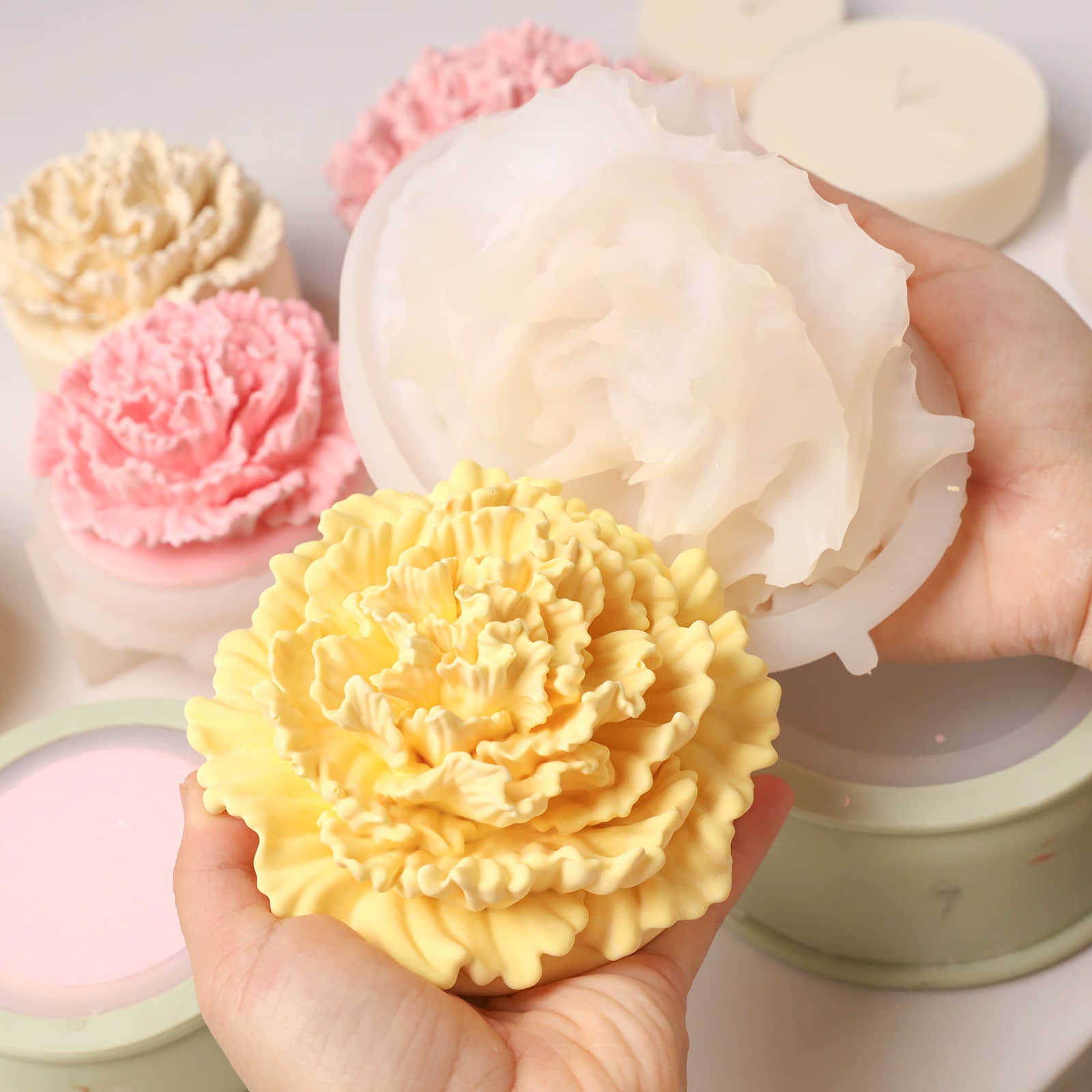 Unmolding a vibrant yellow carnation candle lid from a flexible silicone mold -Boowan Nicole