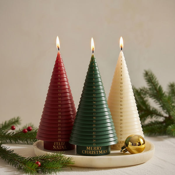 Three advent tree candles—red, green, ivory—burning on a tray with pine; numbered 1–25 - Boowan Nicole