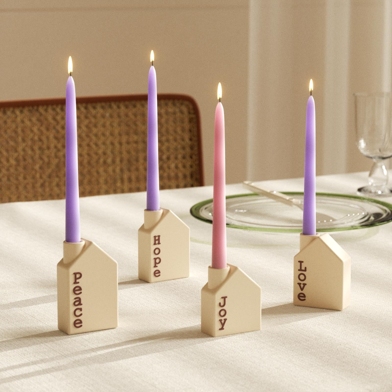 Advent taper candles in house-shaped holders labeled Peace, Hope, Joy, and Love on dining table - Boowan Nicole