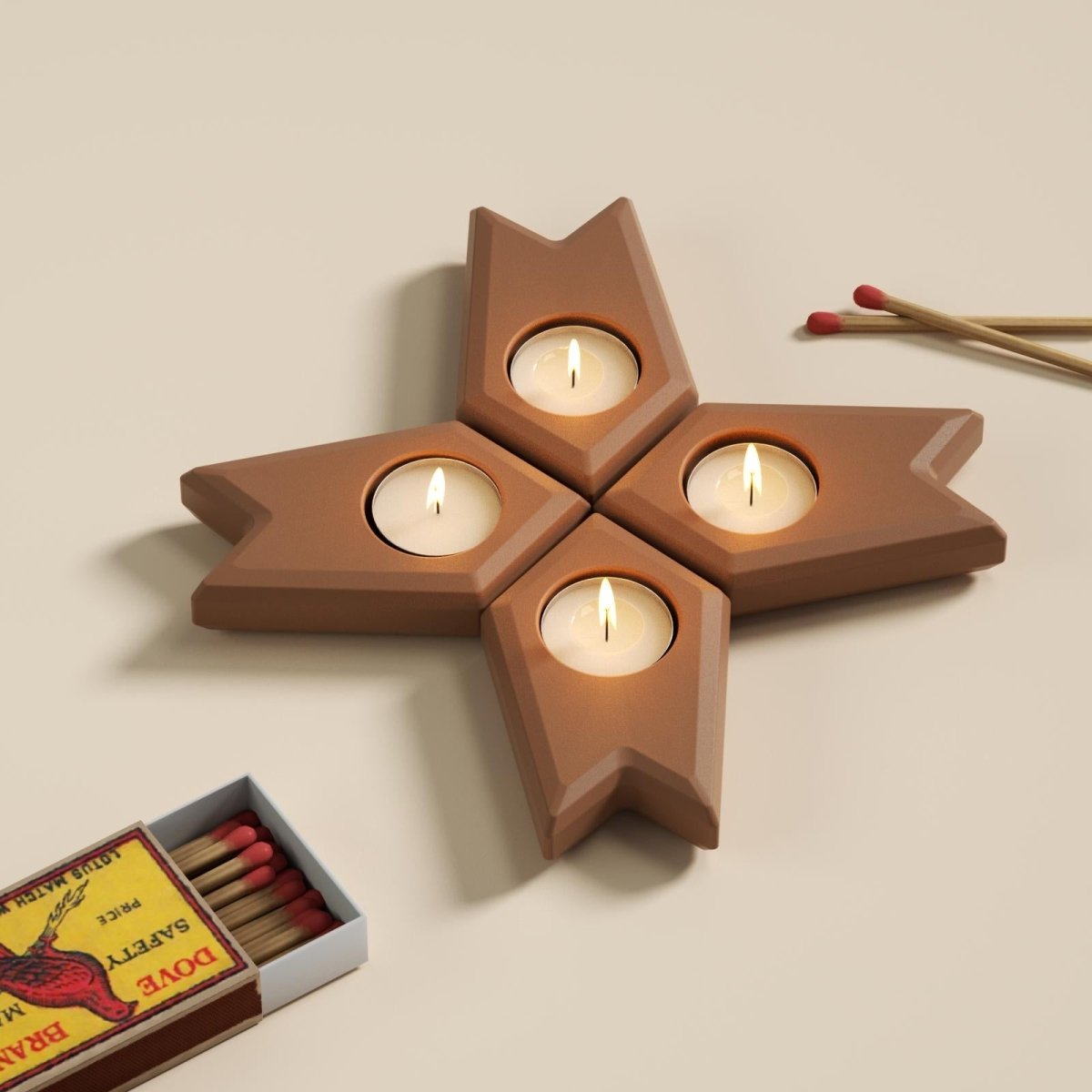 Star-shaped modular Advent candle holders with lit tea lights and matchbox on table - Boowan Nicole