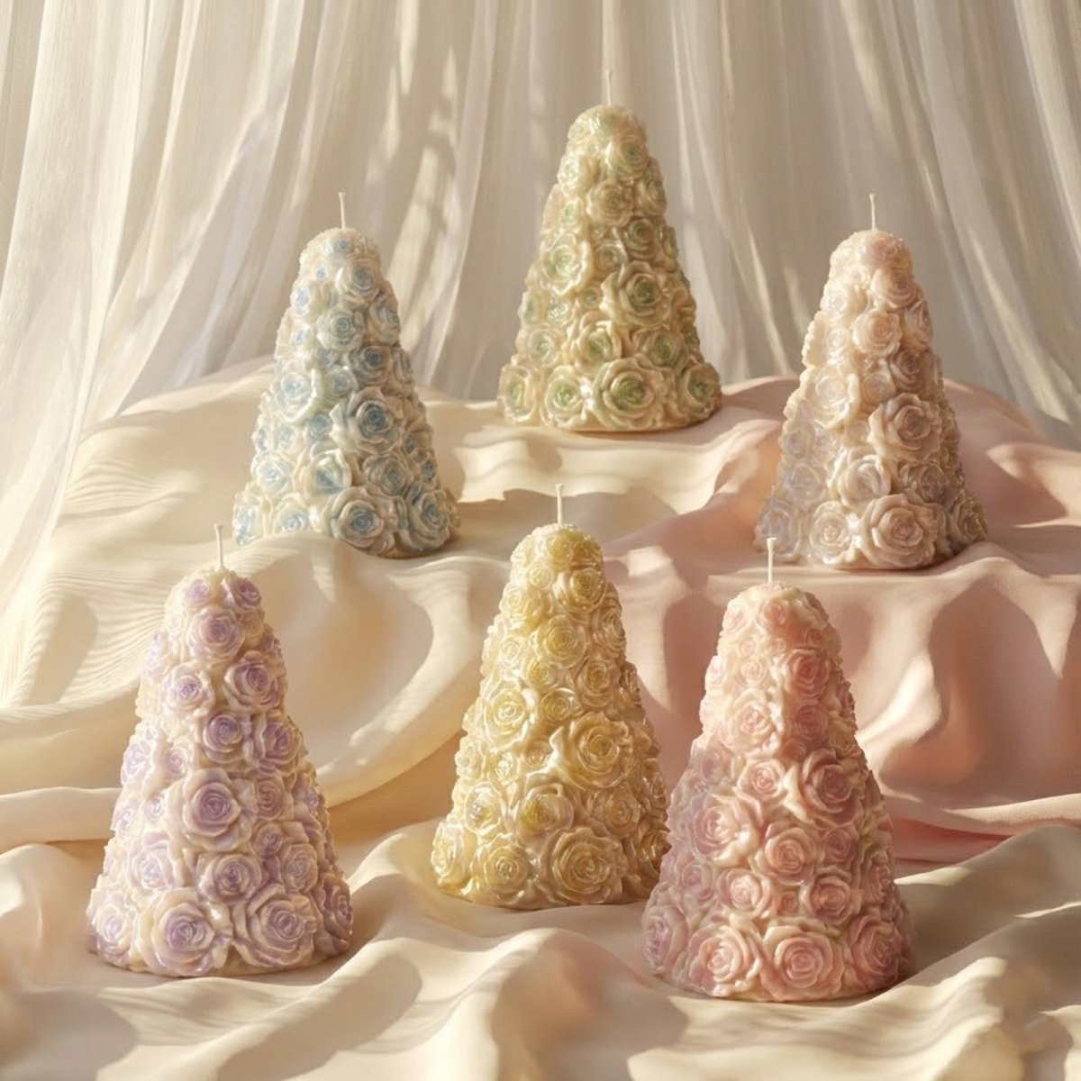 Set of six pastel pearlescent rose tree candles with sculpted blooms displayed on draped fabric in soft sunlight - Boowan Nicole