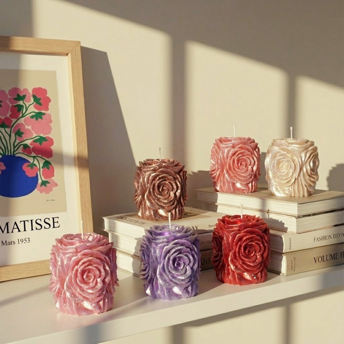 Rose pillar candles in multiple colors styled on books, elegant handmade decor. - Boowan Nicole