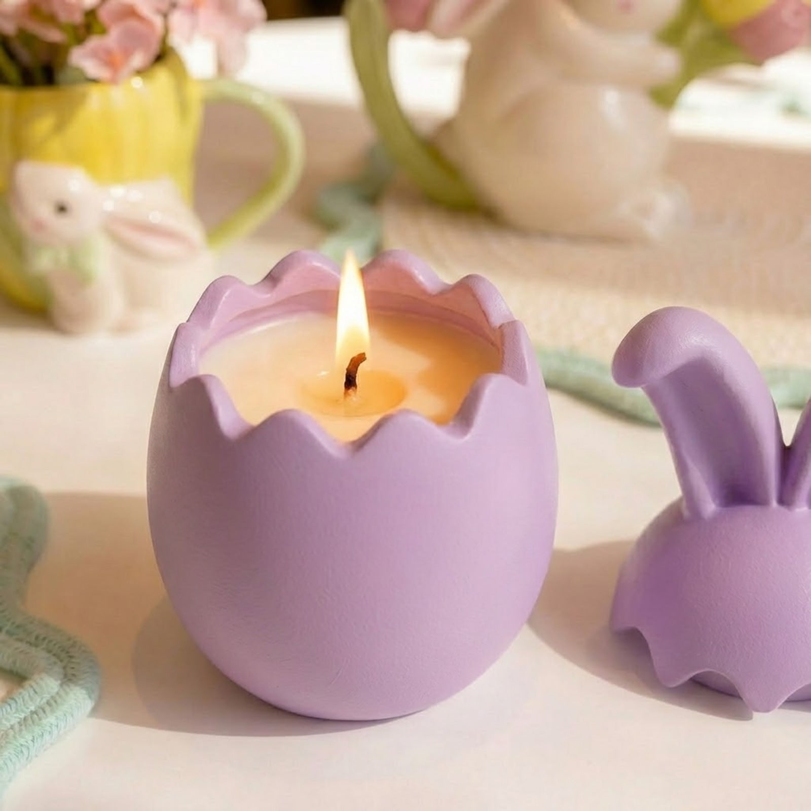 Lit pastel purple bunny ear egg-shaped candle jar, revealing a scented candle inside -Boowan Nicole
