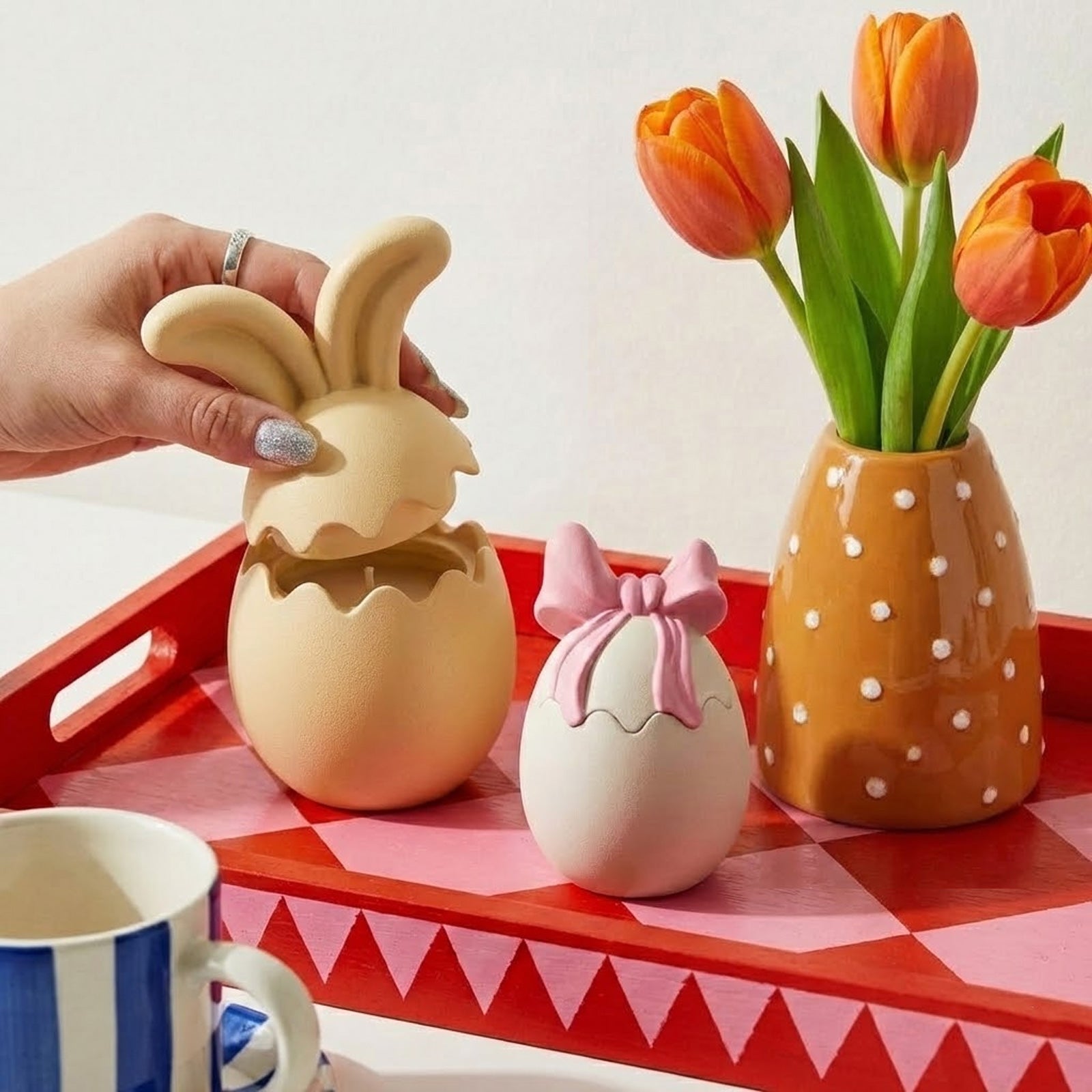 Opening a beige bunny ear egg-shaped candle jar to reveal a scented candle inside -Boowan Nicole