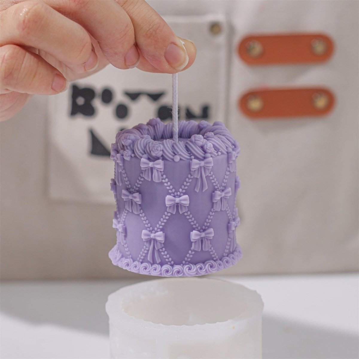Display of a purple bow cake candle, delicately crafted and compact-Boowan Nicole