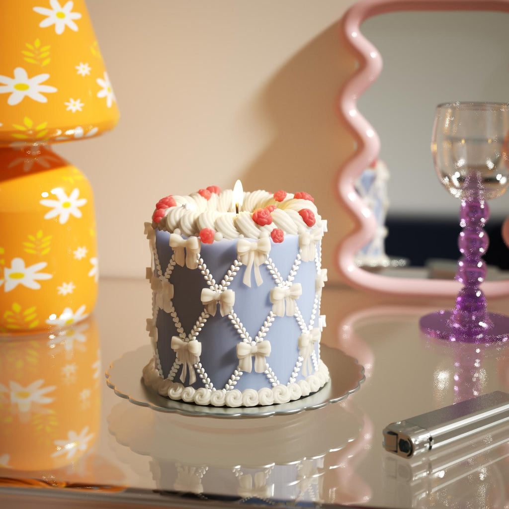 Blue cake candle with bows, roses, and white frosting, perfect for charming decor-Boowan Nicole
