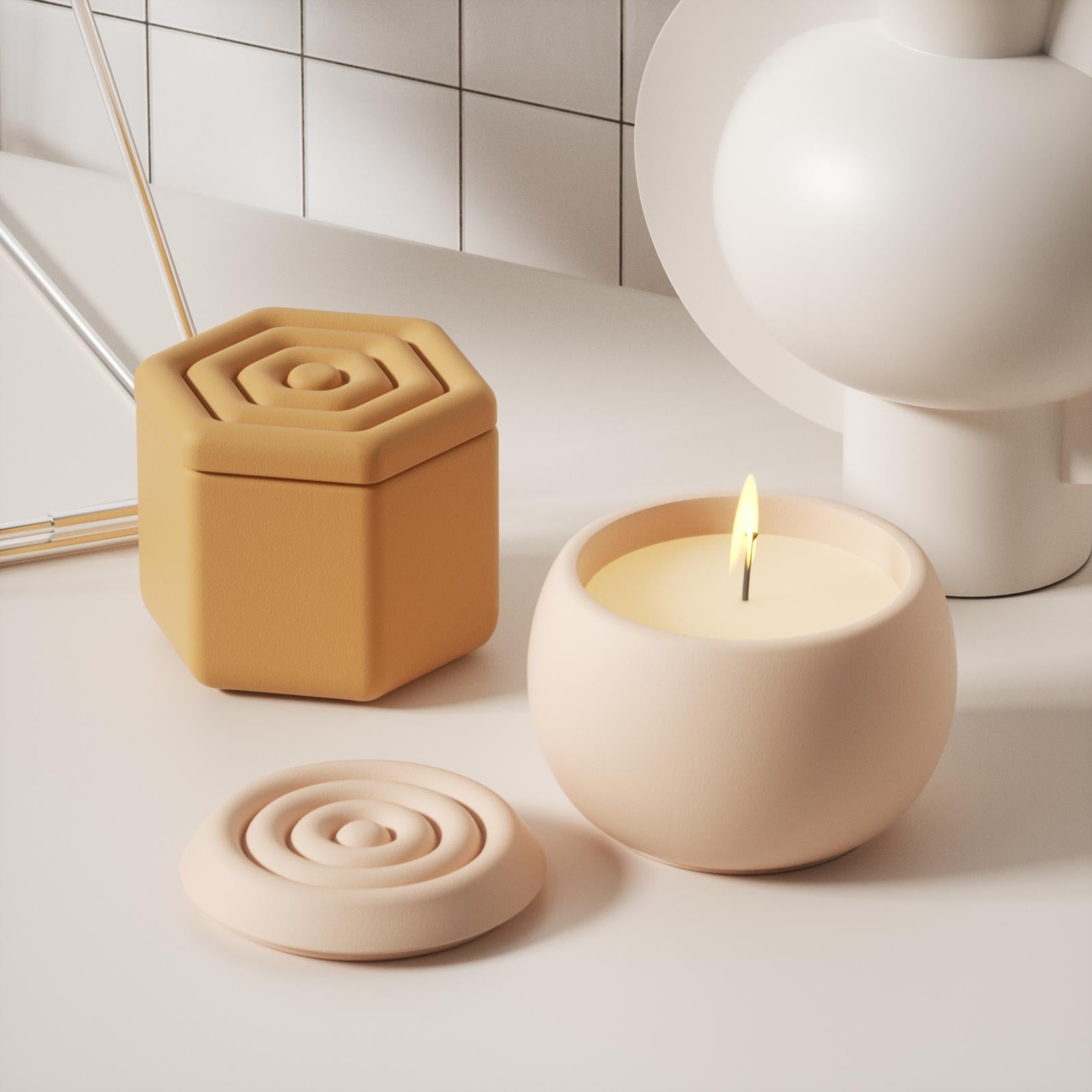 There are two candle jars with corrugated lids, one is polygonal and the other is oval. The candles in the oval candle jar are being lit.