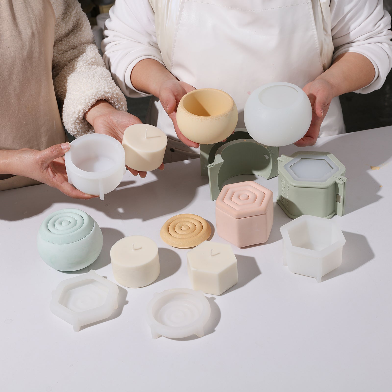 Hand-held display of completed candle jars and corresponding silicone molds and candle refills and corresponding silicone molds.