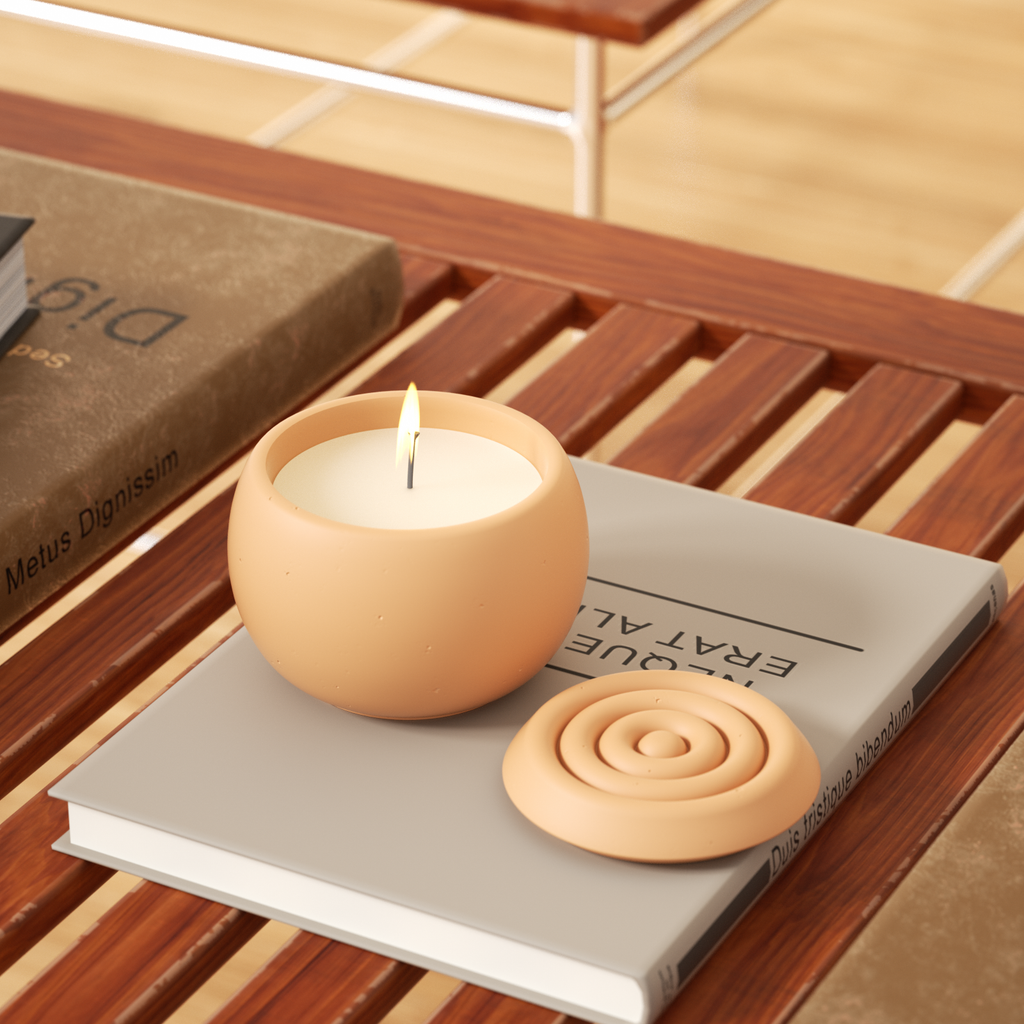 An oval candle jar with lit candles rests on a book with a corrugated lid placed next to it.
