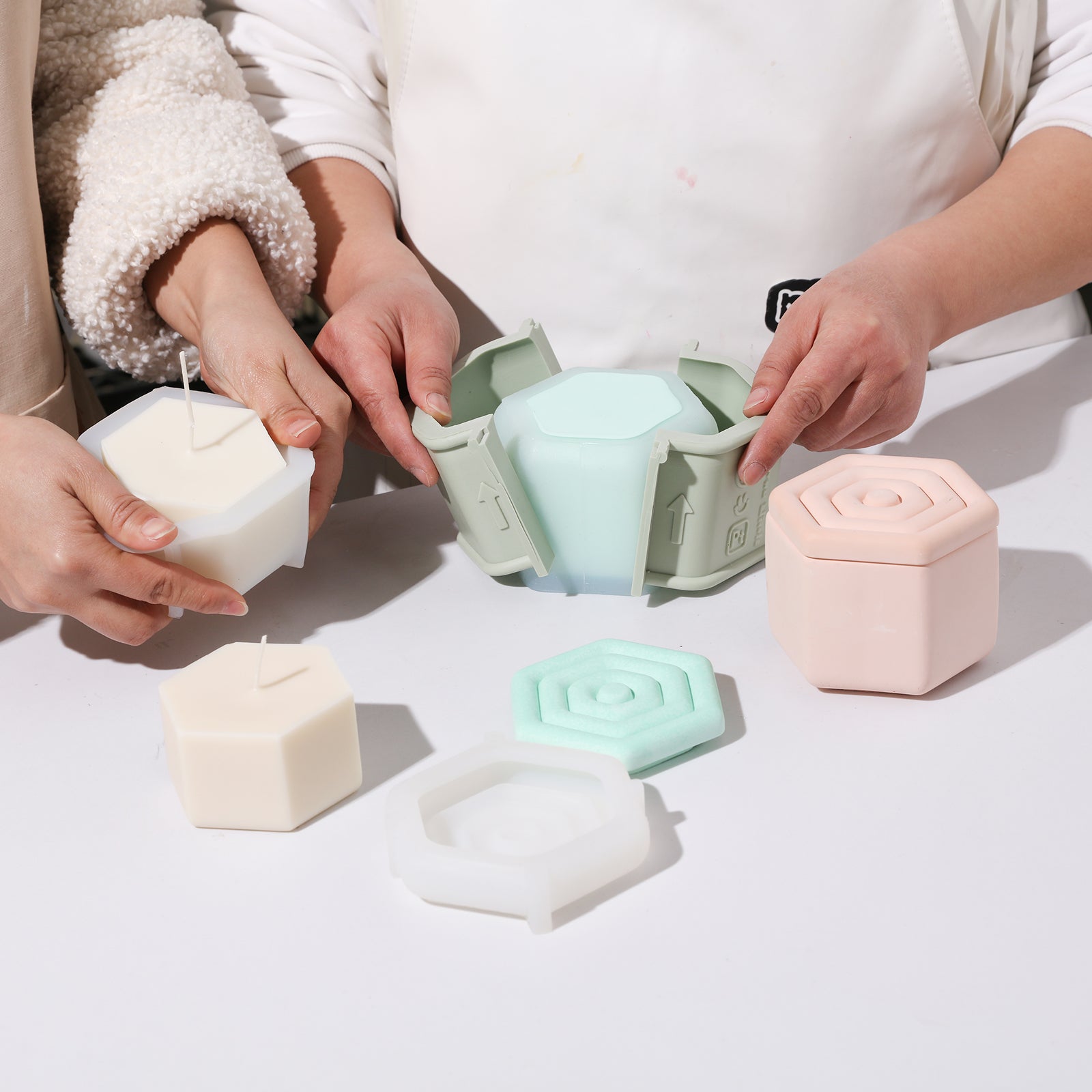 The finished hexagonal candle jar and candle refills emerge from the silicone mold.