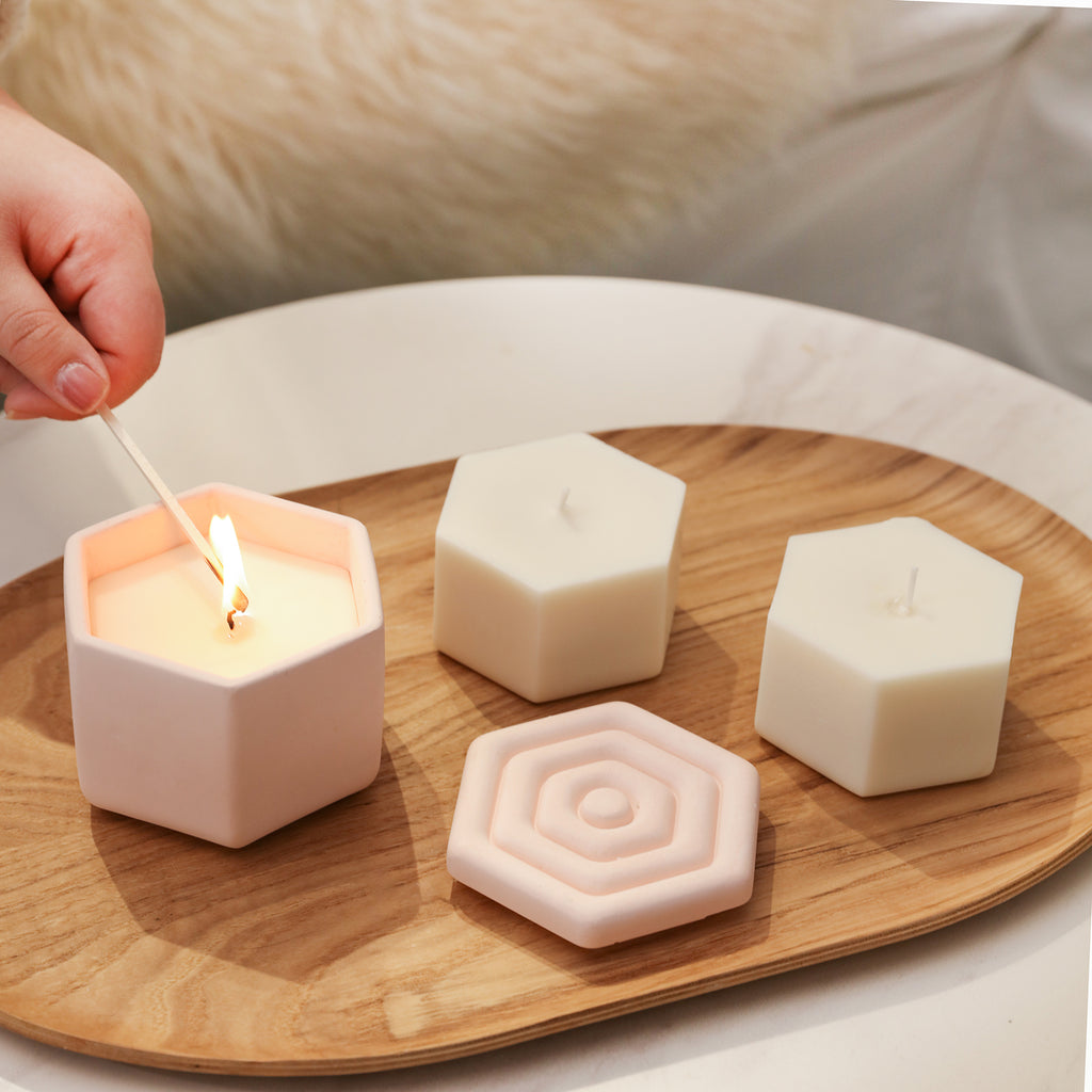 Light the hexagonal candle jar in the tray with two candle refills placed next to it.