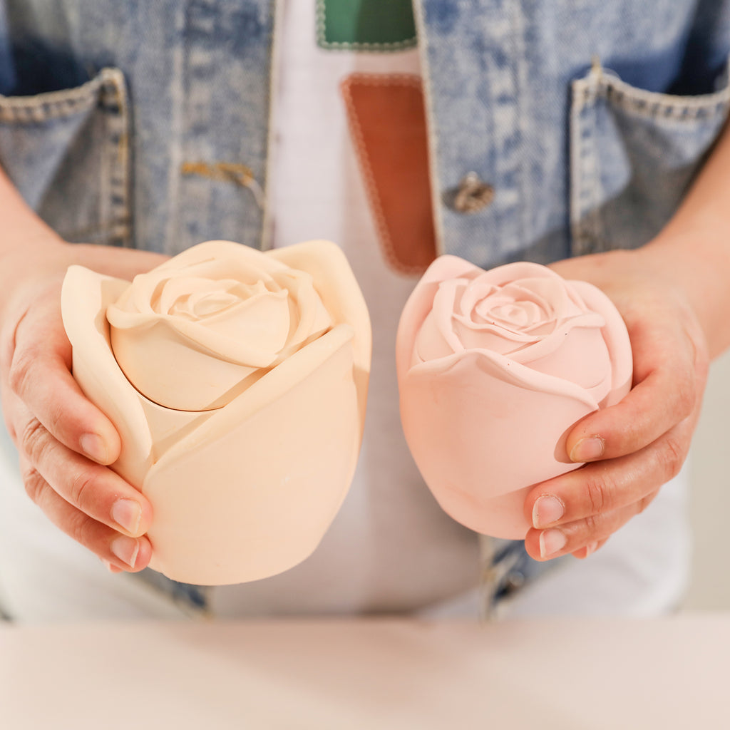 Holding a large and small pink Rose Reverie Candle Jar-Boowan Nicole