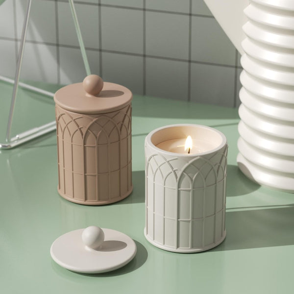 cathedral light  concrete candle jars with embossed design, one lit, one closed, on a mint green table-Boowan Nicole