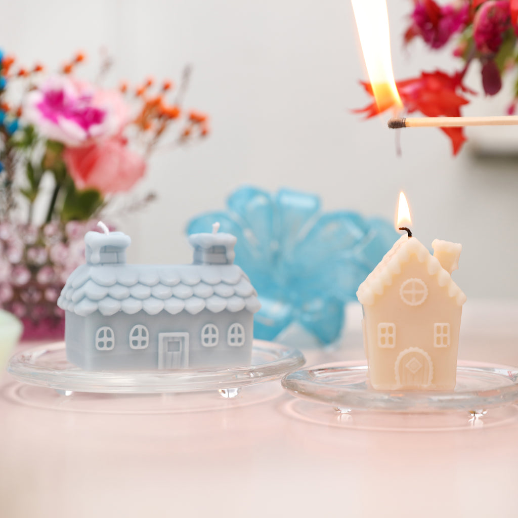 Single and double chimney house candles are placed on glass trays, and the single chimney house candle is being lit.